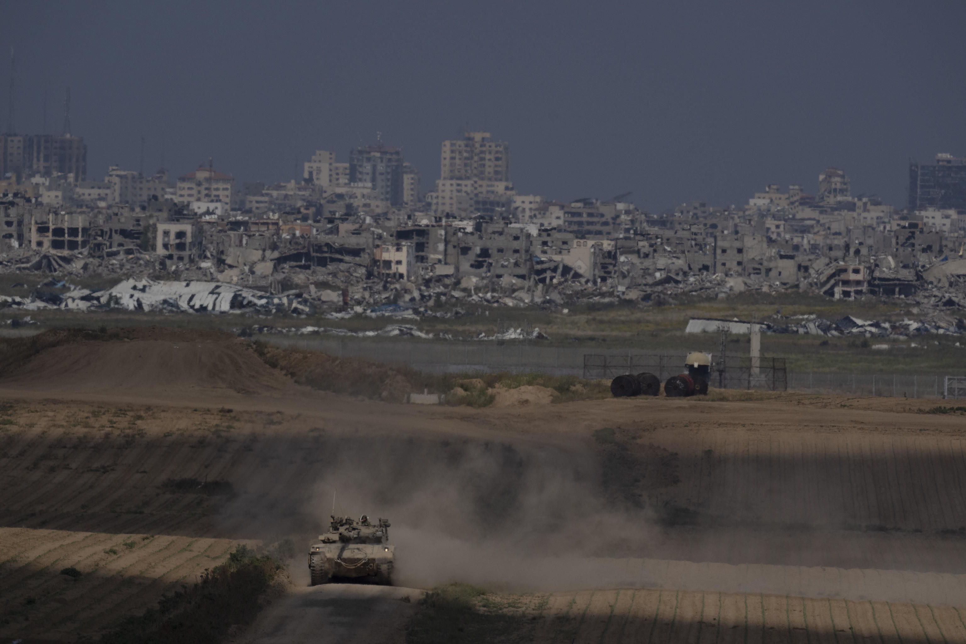 Israeli soldiers move on the top of a tank near the Israeli-Gaza border.