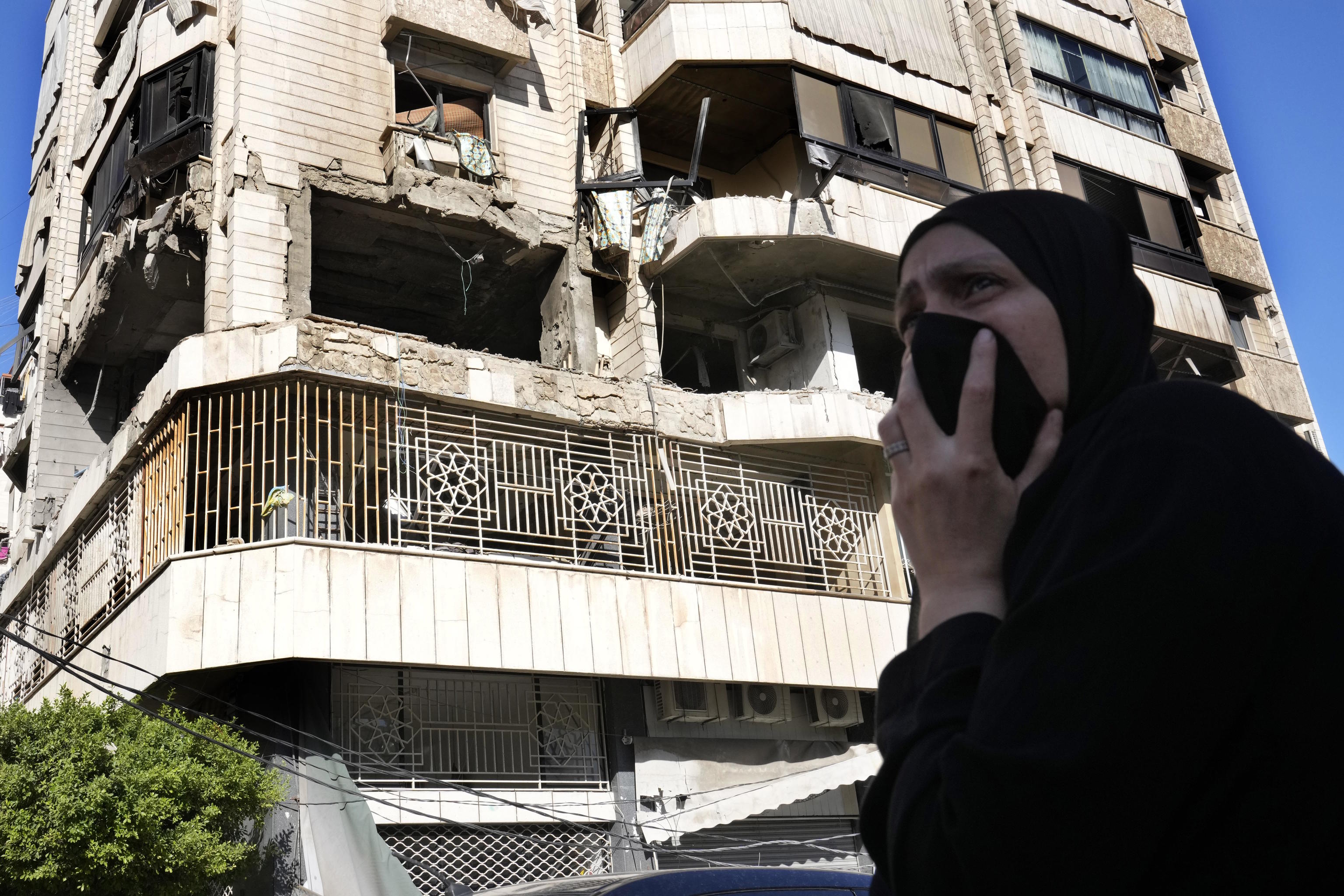 A woman reacts in front abuilding hit by Israeli airstrike, in central Beirut.