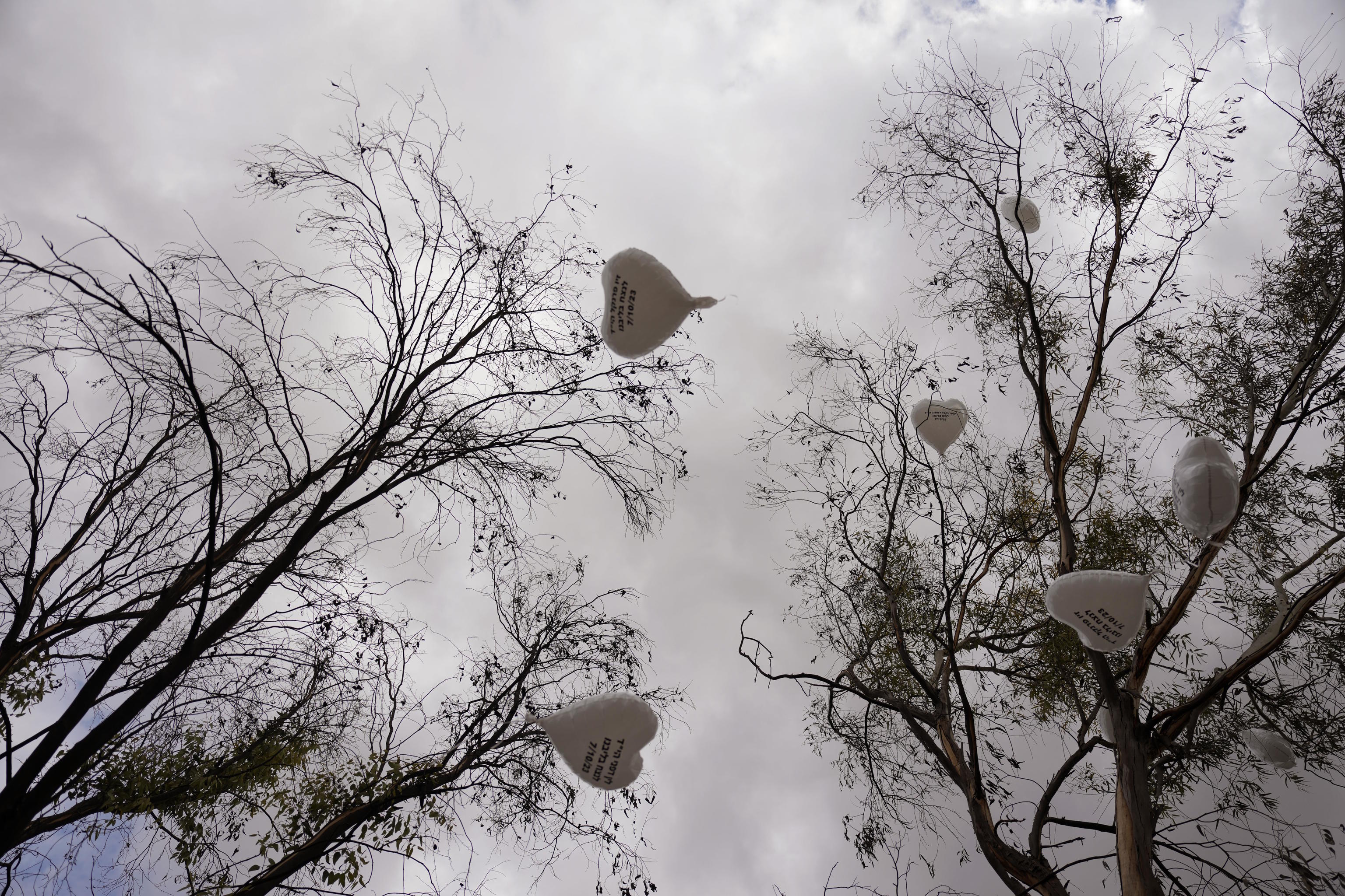 Balloons with the name of victims are released during a ceremony.