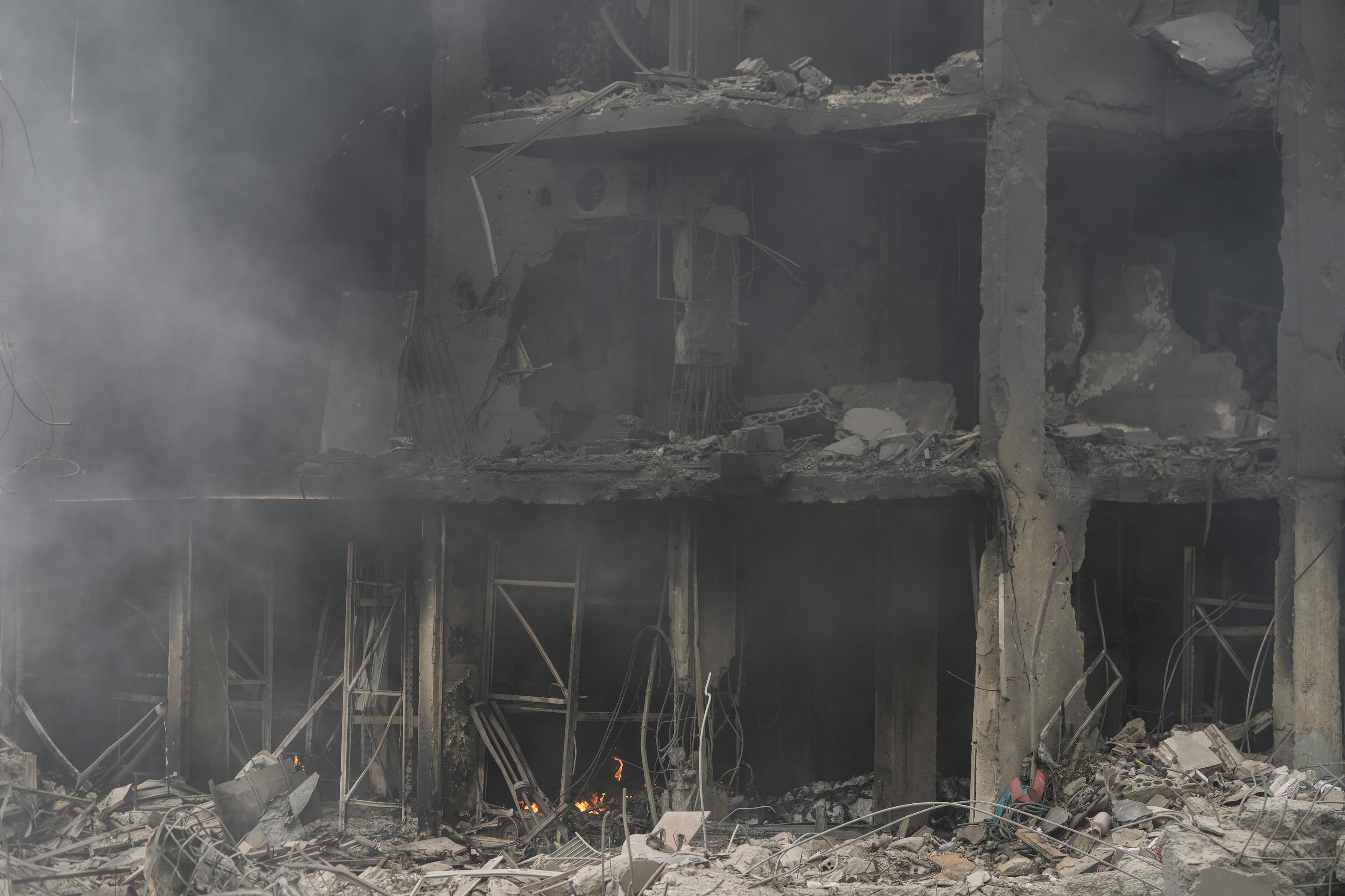 Smoke rises from destroyed buildings at the site of an Israeli airstrike hit.