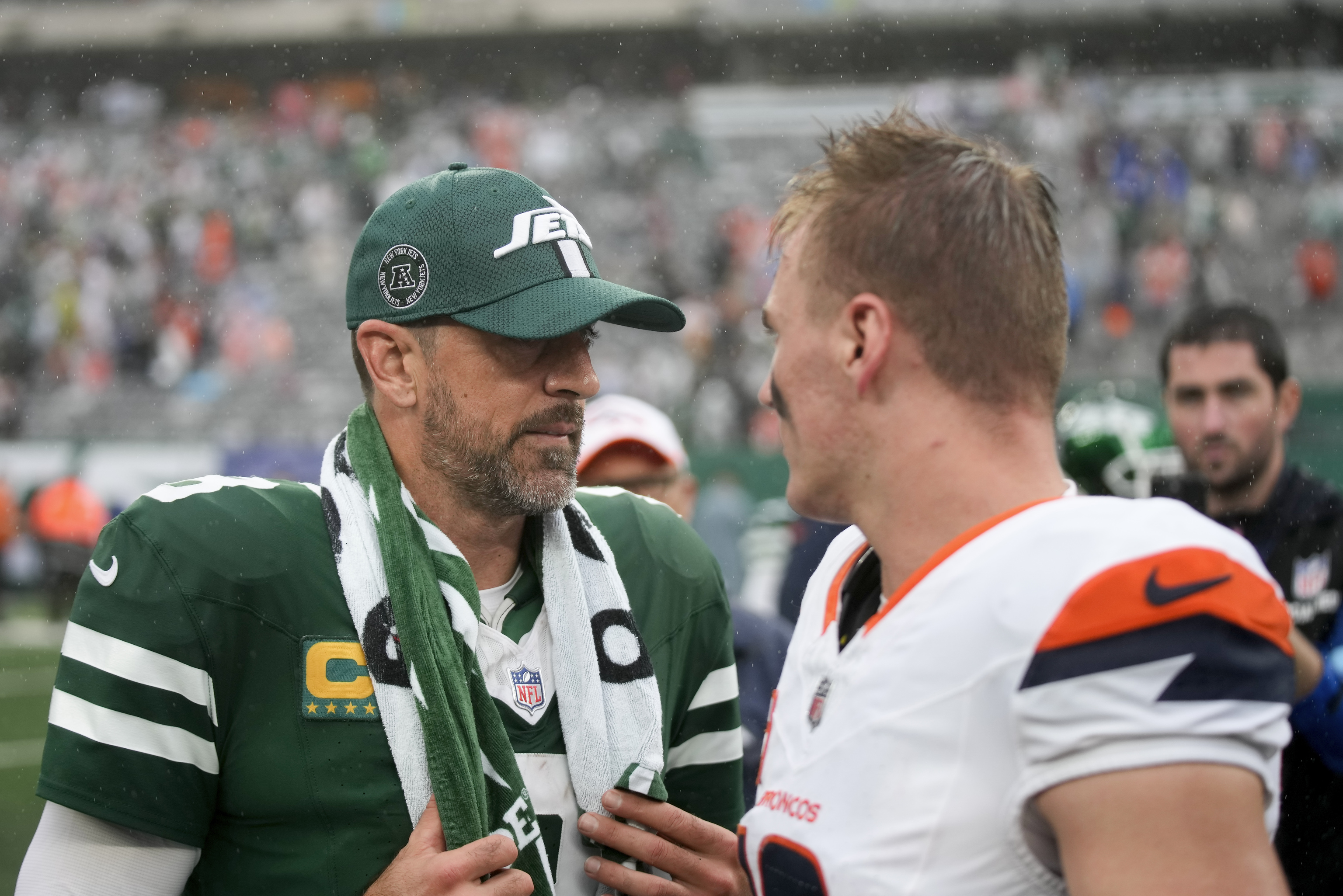 New York Jets quarterback Aaron Rodgers (8) talks with Denver Broncos quarterback Bo Nix.