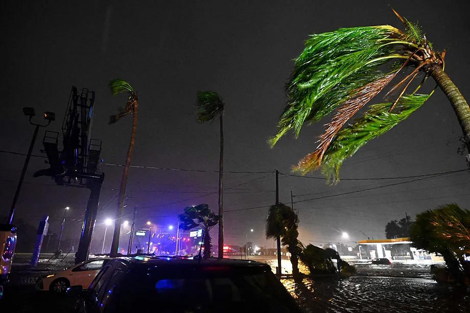 Palm trees bend in the wind after Milton made landfall in Brandon, Florida.