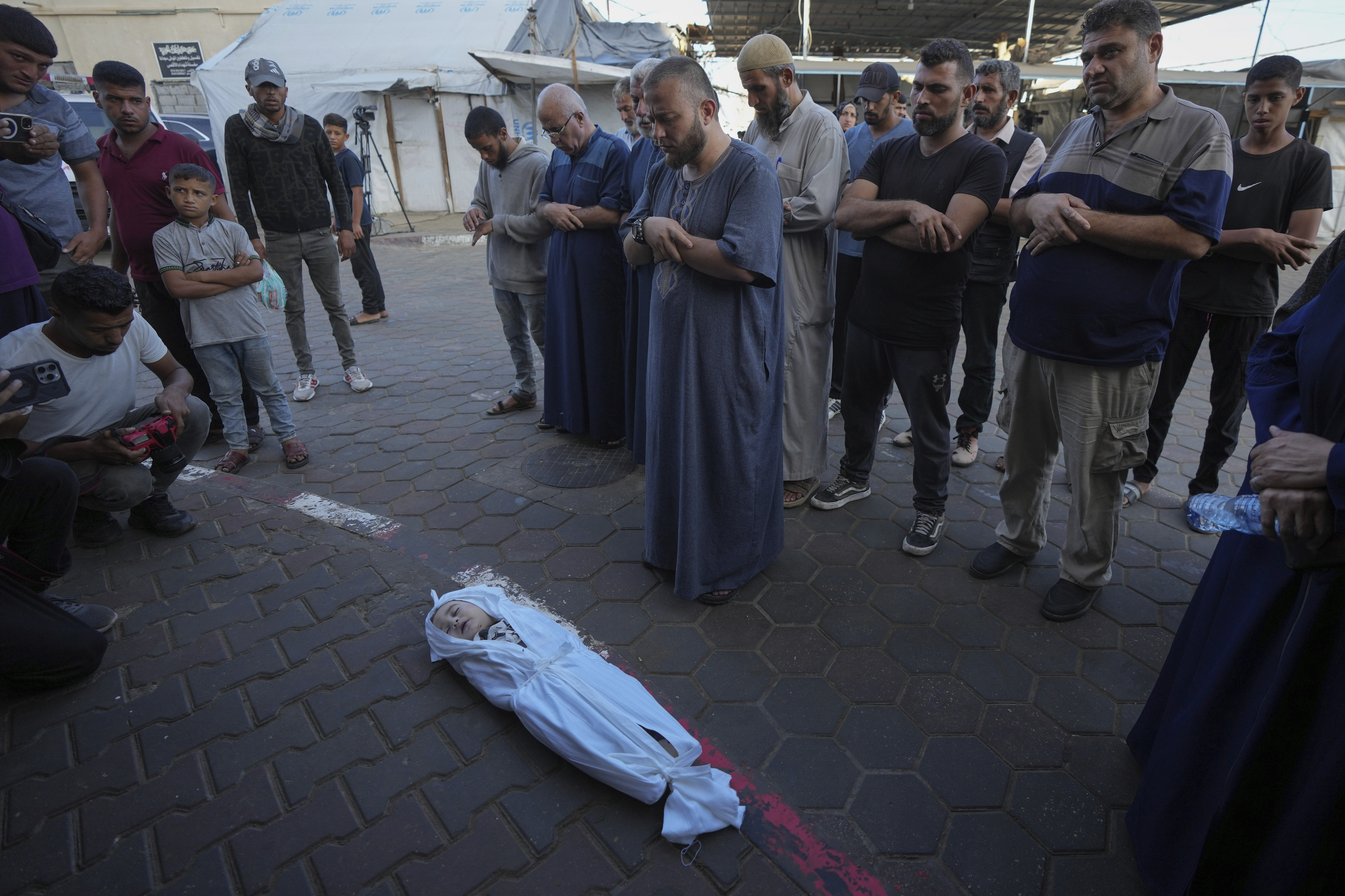 Mourners pray over the body of a Palestinian child, Hosam Al Khaldi, killed in the Israeli bombardment of the Gaza Strip
