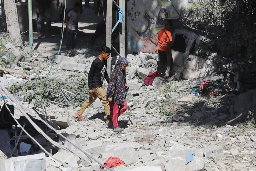 People inspect the damage following an Israeli air strike