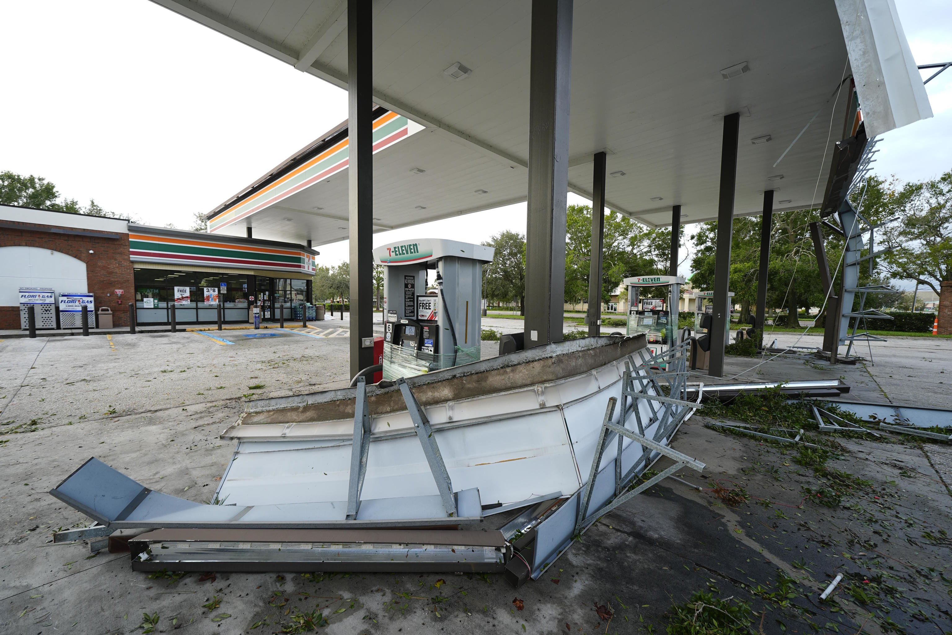 Debris and an awning of a gas station sits on the ground.