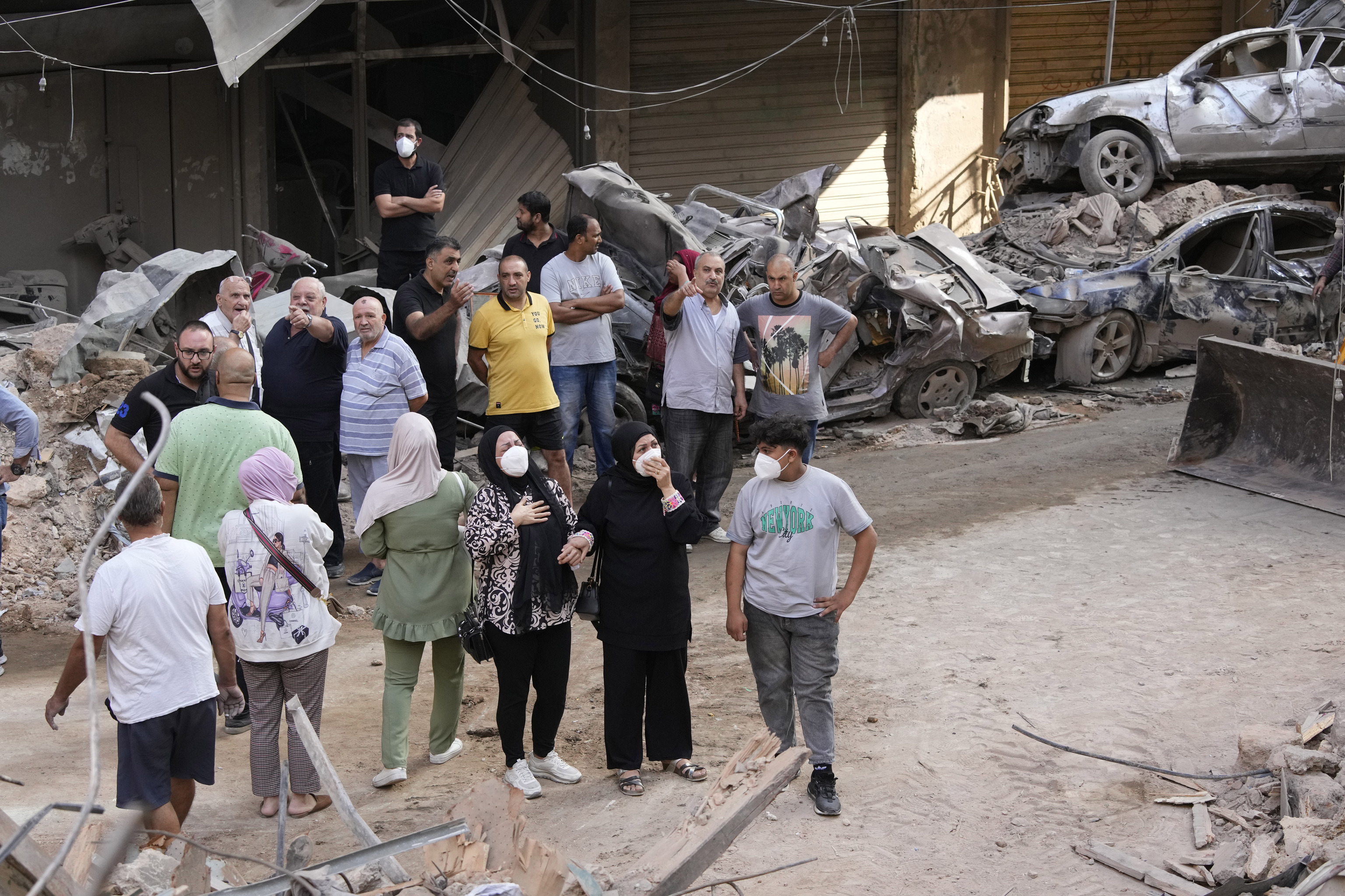 Residents react in front of their destroyed apartment at the site of Thursday's Israeli airstrike in Beirut