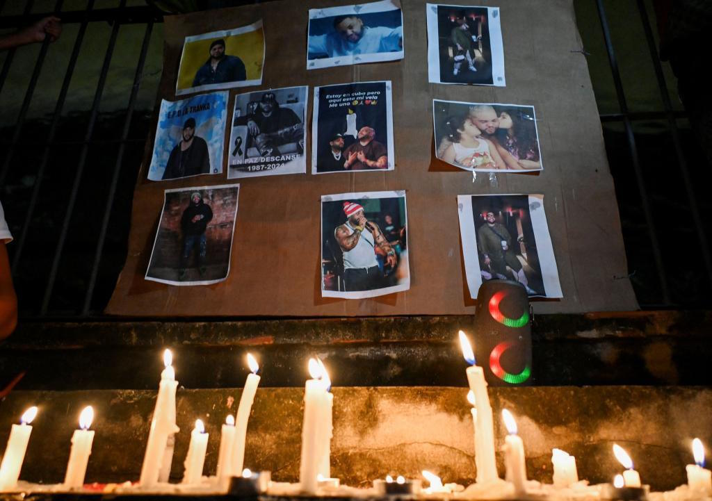 Cubans light candles next to pictures of late reggaeton singer El Taiger.