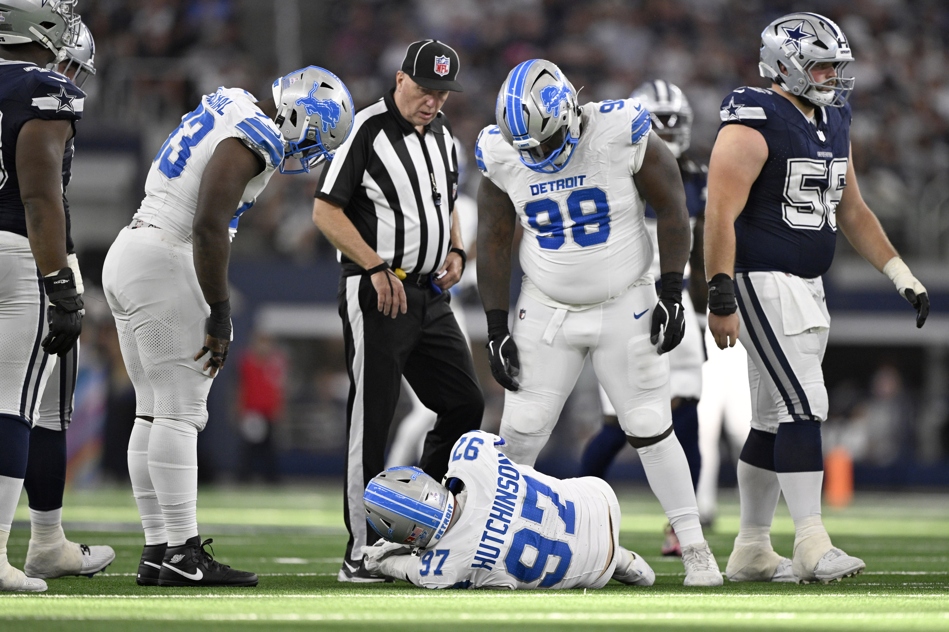 Detroit Lions defensive end Aidan Hutchinson (97) is attended to by team staff after suffering an unknown injury.