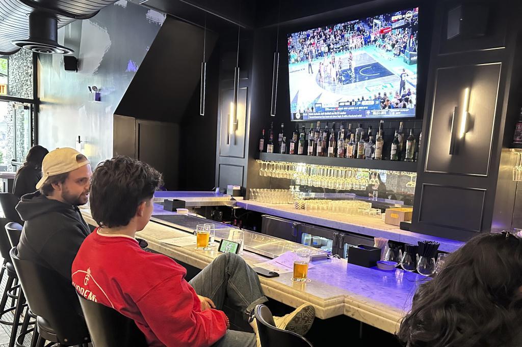 Customers at Signature Bar & Restaurant in Chicago's South Loop neighborhood near the Chicago Sky's home at Wintrust Arena sit at the bar as Game 2 of the WNBA finals between the New York Liberty and Minnesota Lynx