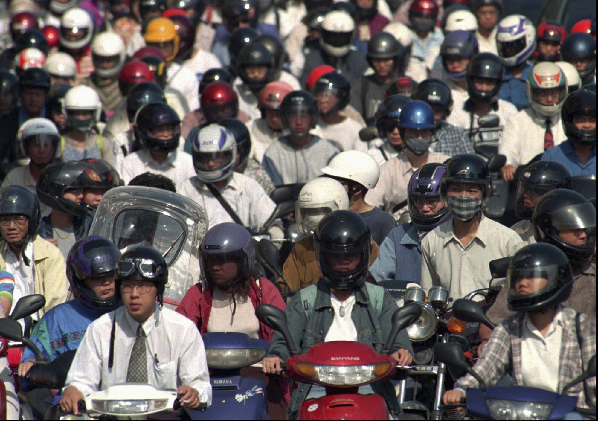 Taiwanese motorcycle and scooter riders wait at a stop light in Taipei