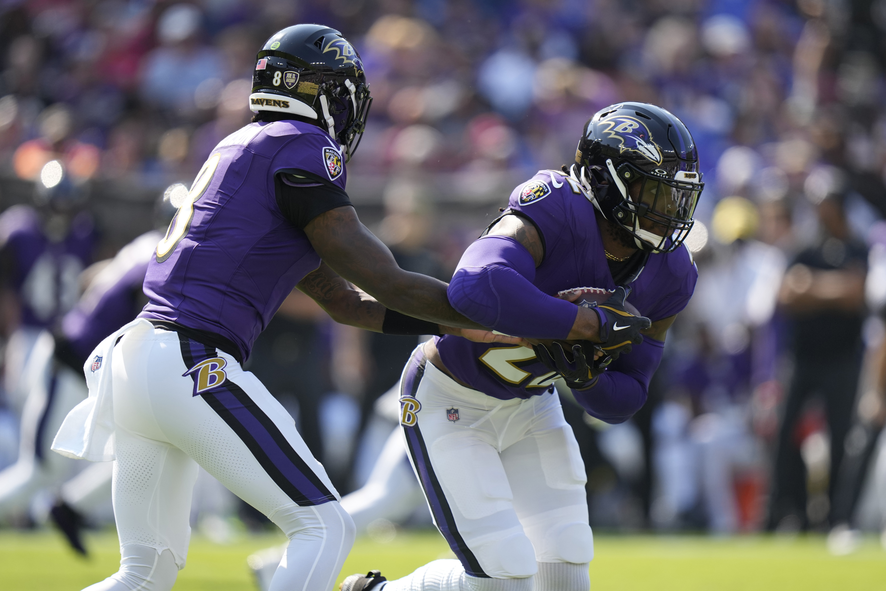 Baltimore Ravens quarterback Lamar Jackson (8) hands off to running back Derrick Henry, right