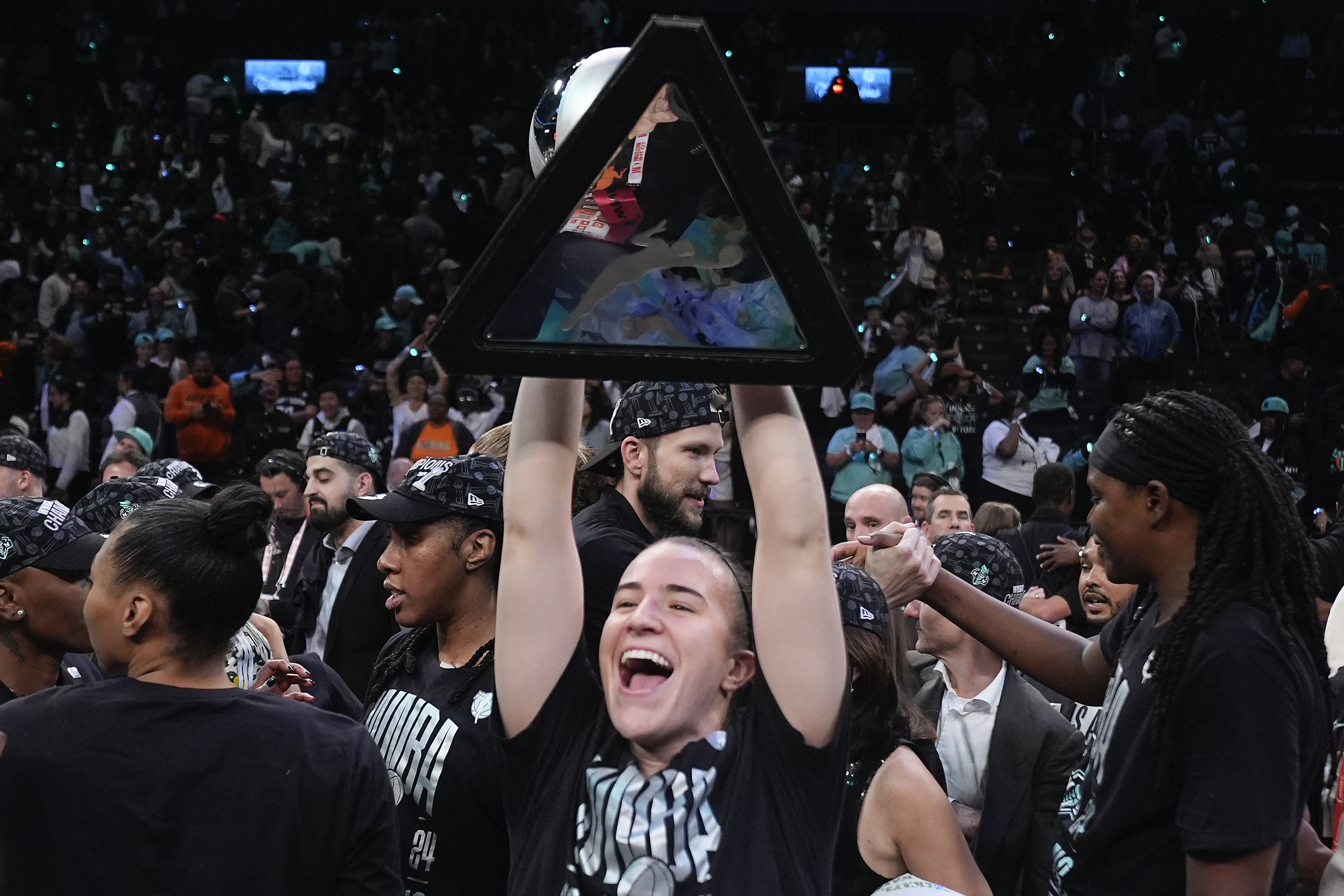 New York Liberty guard Sabrina Ionescu holds up the championship trophy after the Liberty defeated the Minnesota Lynx in Game 5.