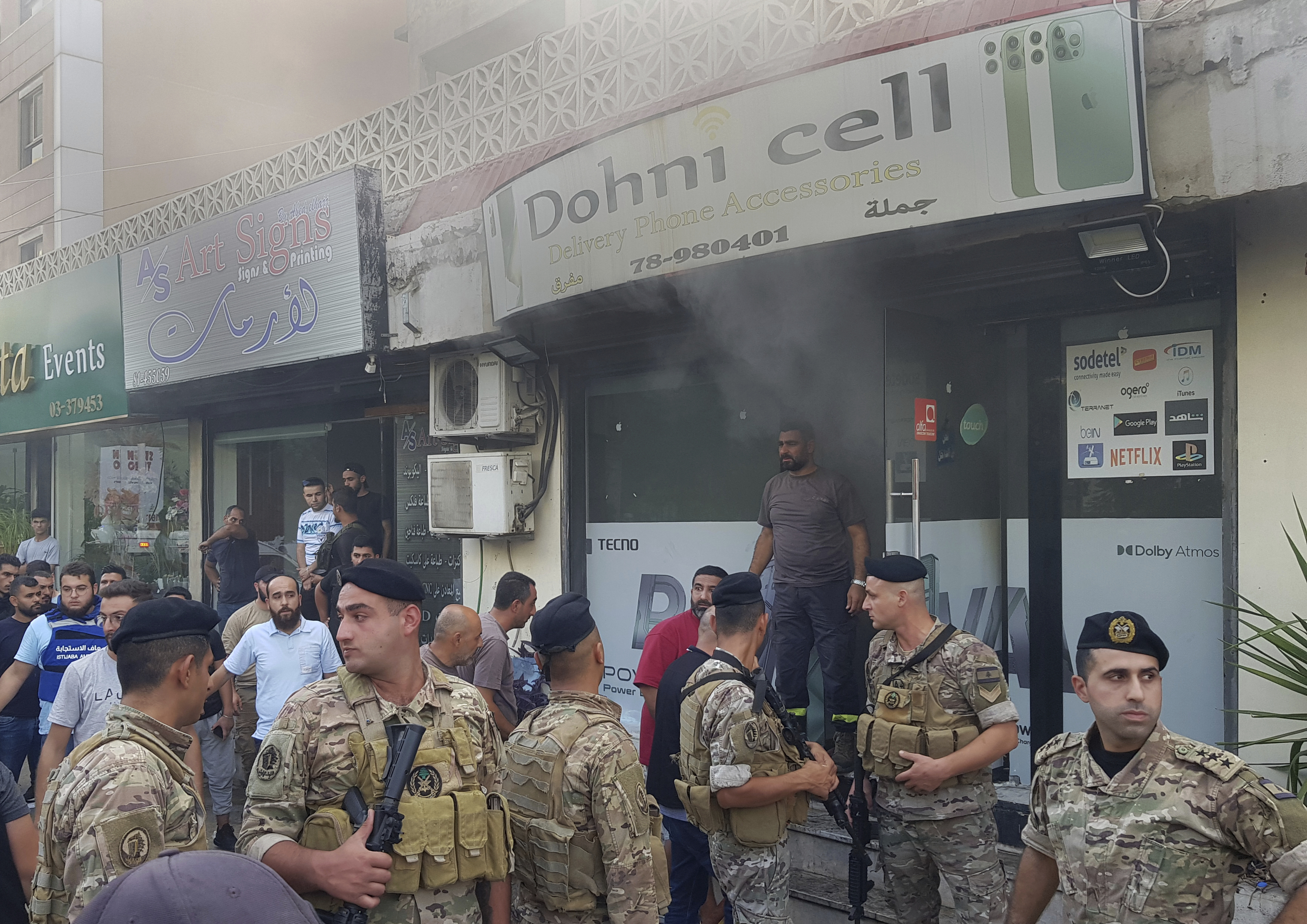 Lebanese soldiers gather outside a damaged mobile shop