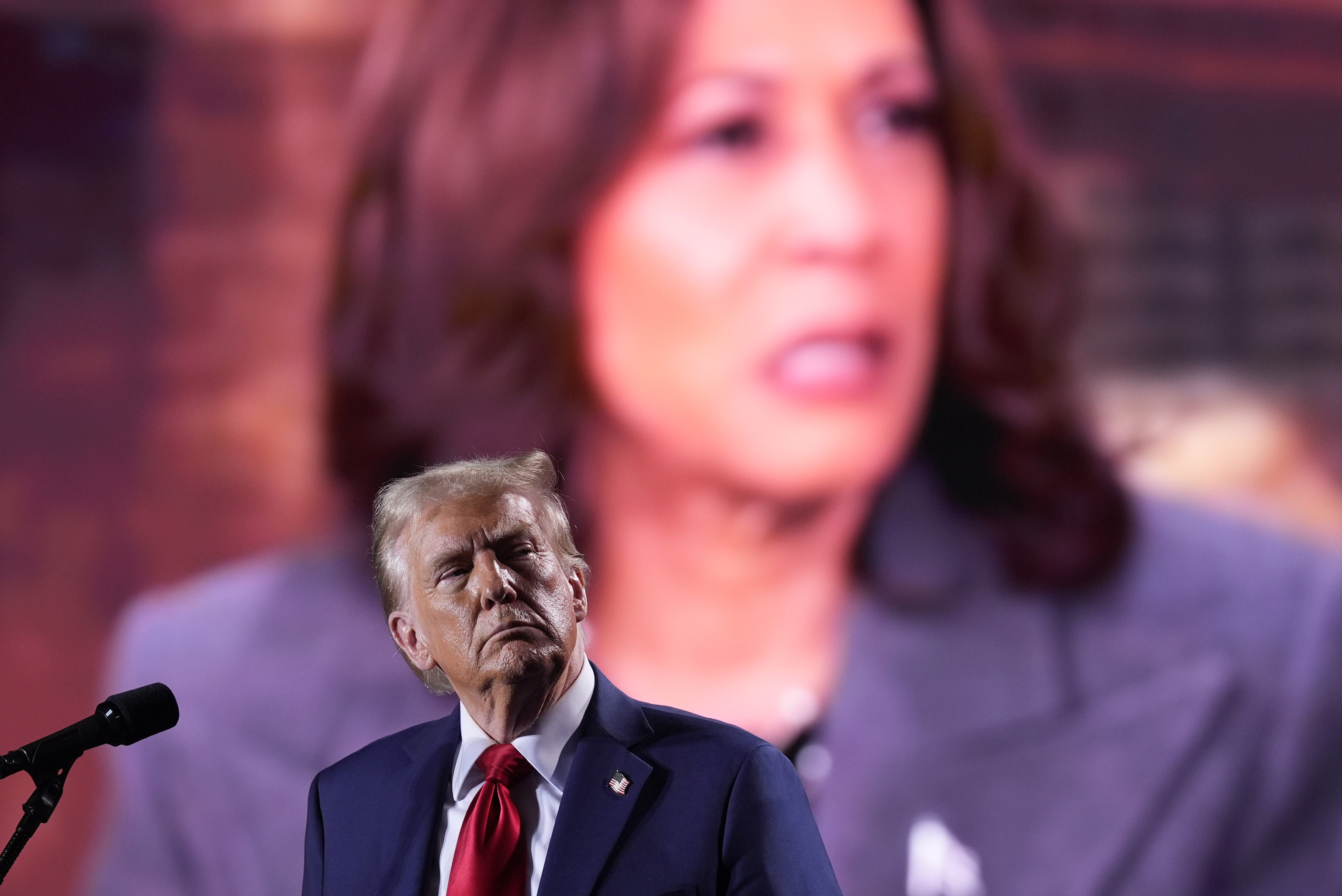 Republican presidential nominee former President Donald Trump watches as a video with Democratic presidential nominee Vice President Kamala Harris