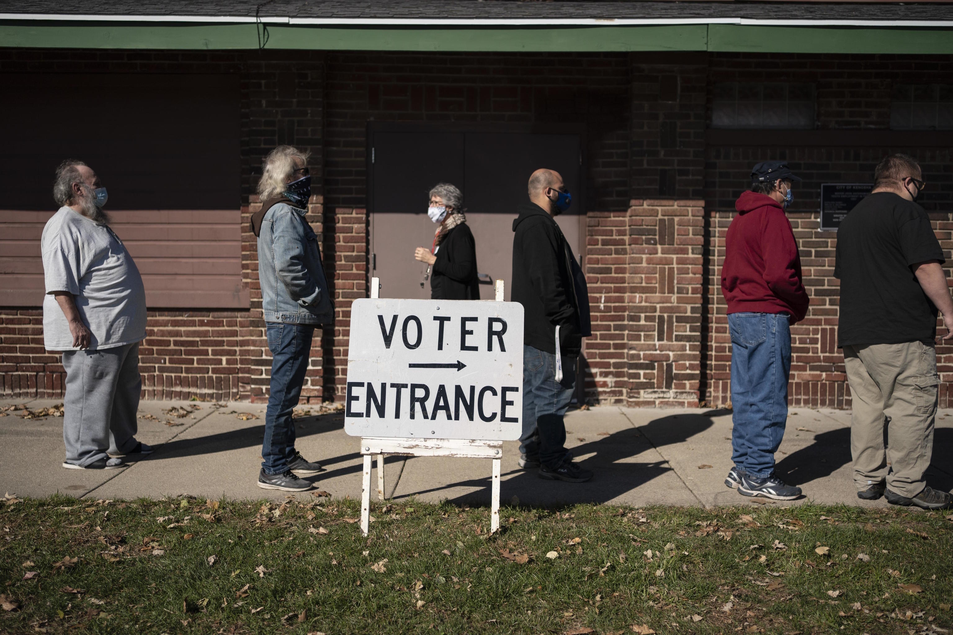 Voters wait in line outside a polling center on Election Day, in Kenosha, Wis.