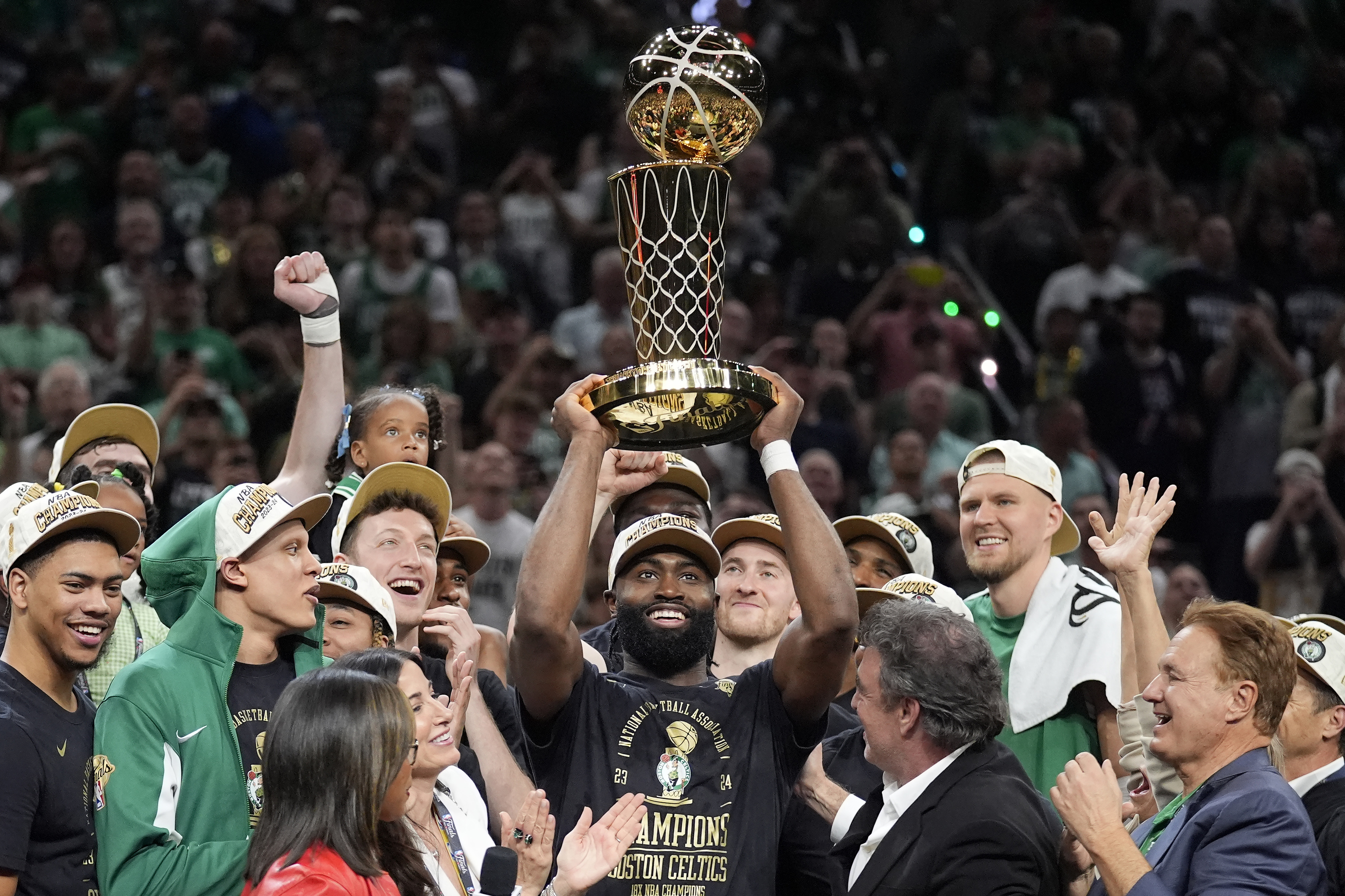 Boston Celtics guard Jaylen Brown, center, holds up the Larry O'Brien Championship Trophy.