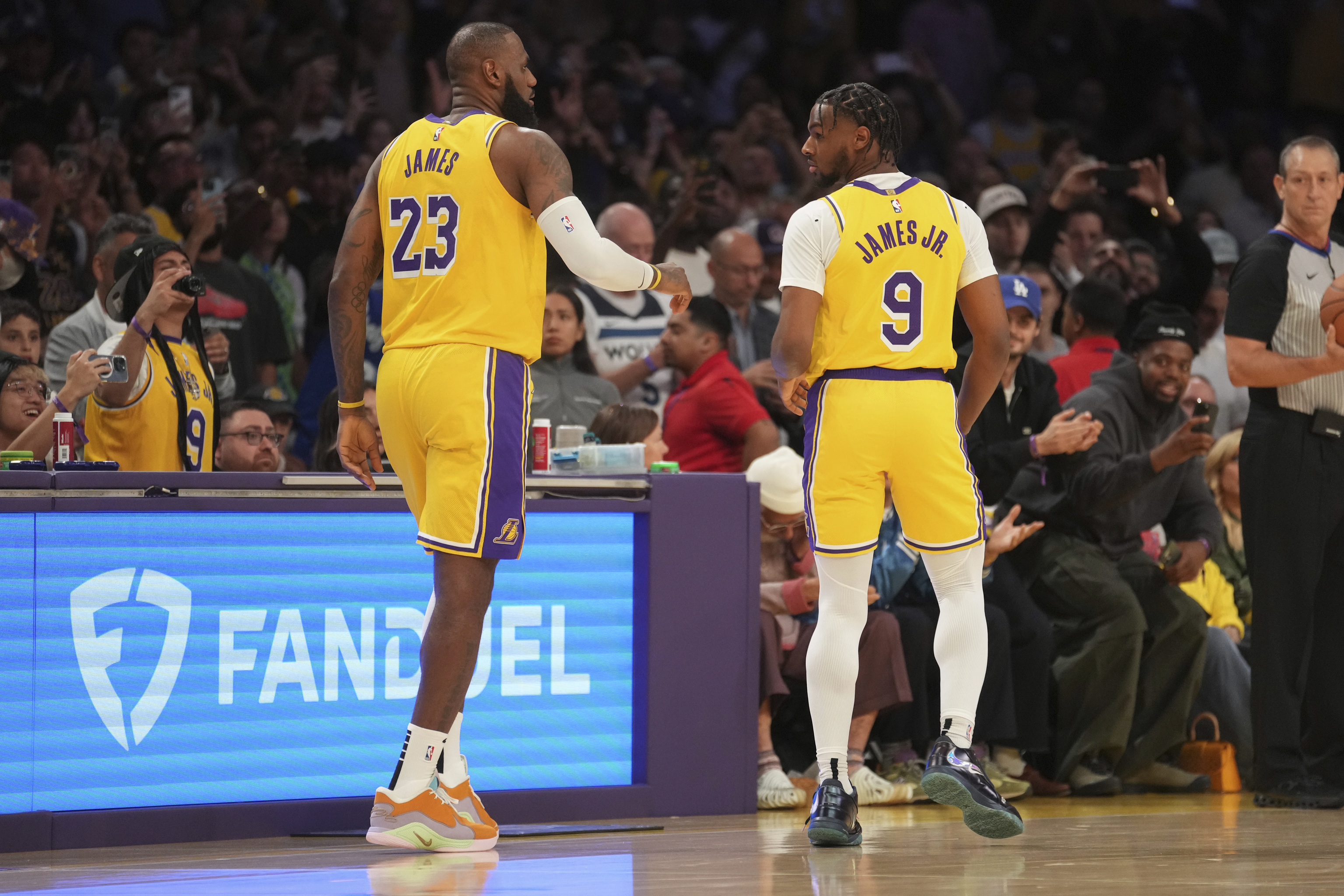 Los Angeles Lakers forward LeBron James (23) looks to pass to guard Bronny James (9) during the first half of an NBA basketball game