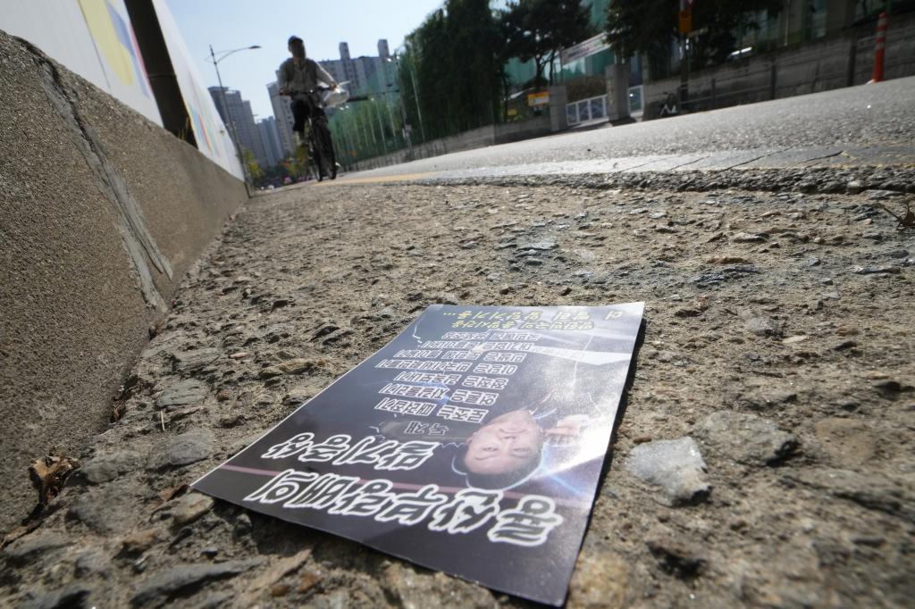 A propaganda leaflet showing South Korean President Yoon Suk Yeol presumably sent by North Korea is seen on a road in Seoul