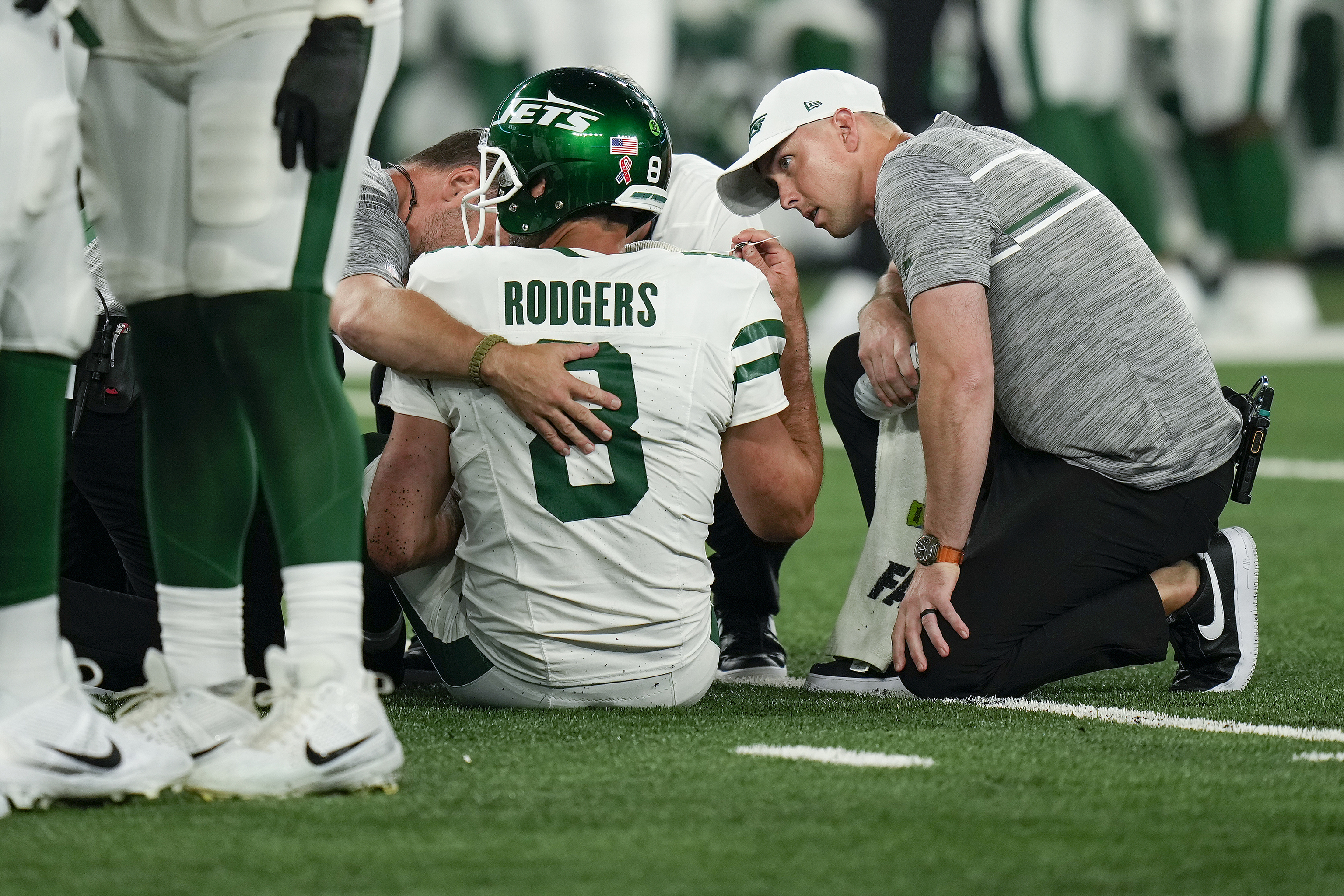 New York Jets quarterback Aaron Rodgers (8) is tended to on the field.