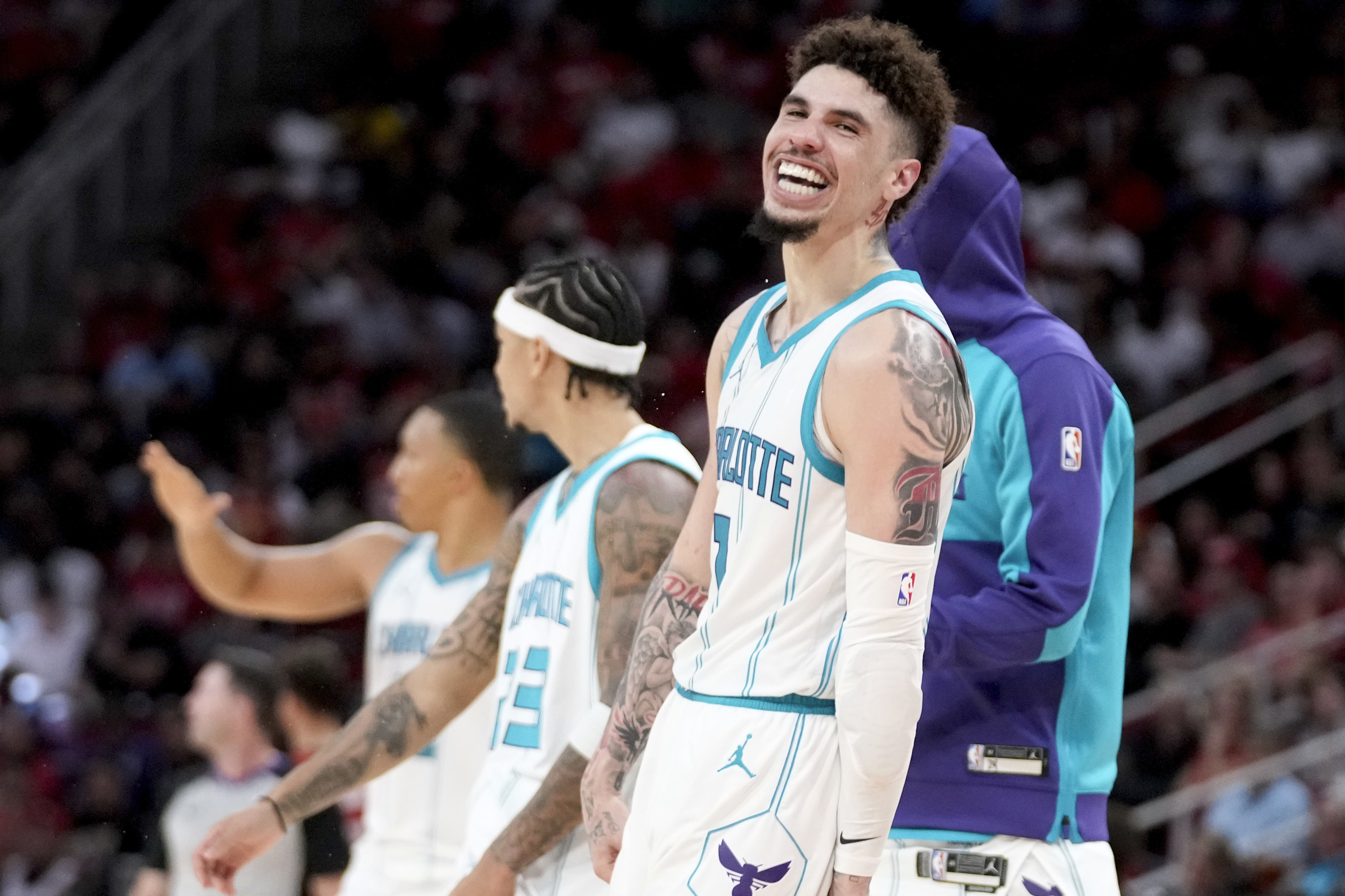 Charlotte Hornets guard LaMelo Ball, right, reacts after making a three point basket.