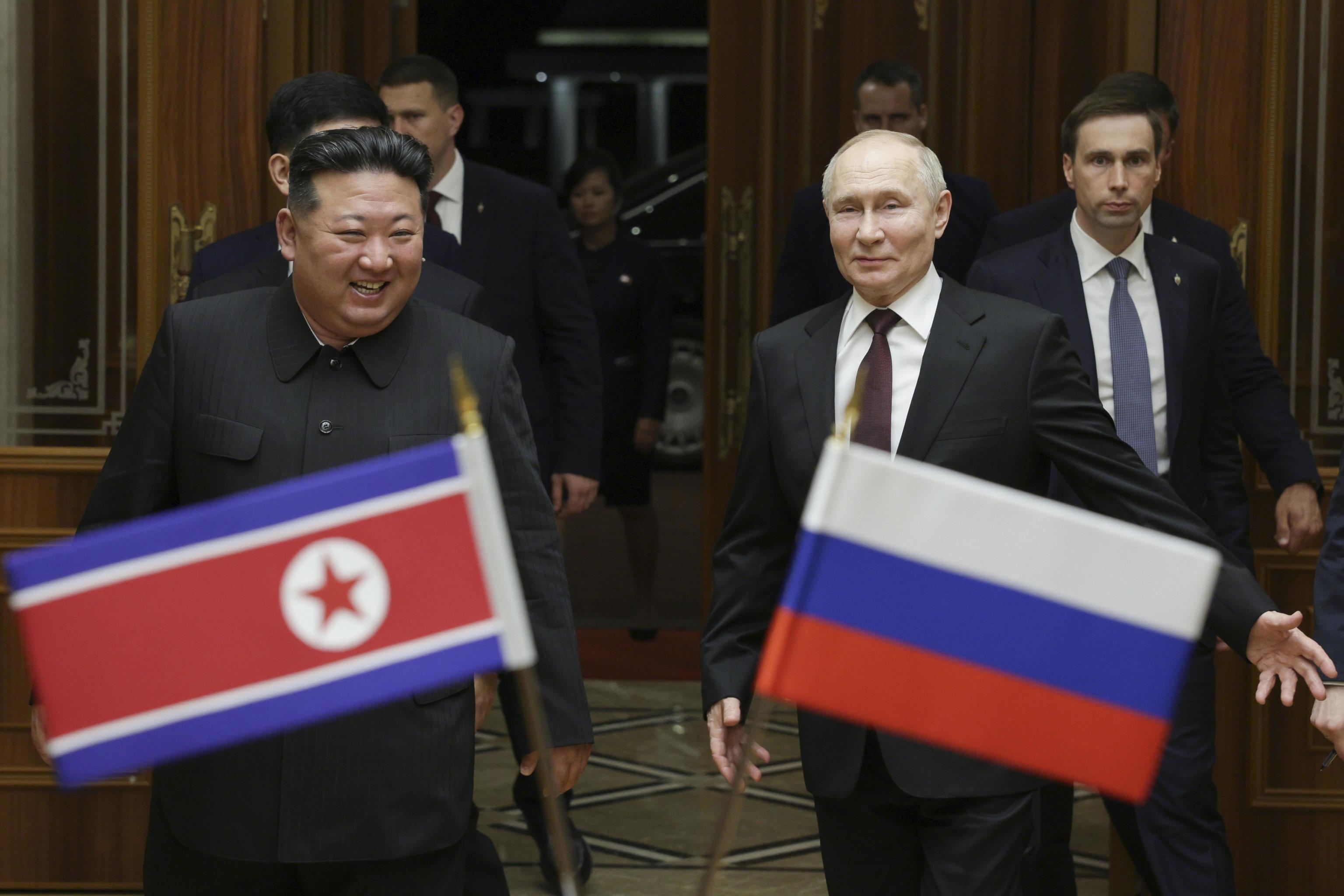 In this file image, Putin (right) and Kim Jong Un smile during a meeting.