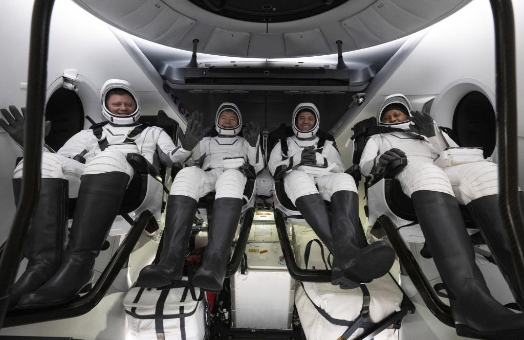 Roscosmos cosmonaut Alexander Grebenkin, left, NASA astronauts Michael Barratt, second from left, Matthew Dominick, second from right, and Jeanette Epps, right, inside the SpaceX Dragon Endeavour spacecraft onboard the SpaceX recovery ship