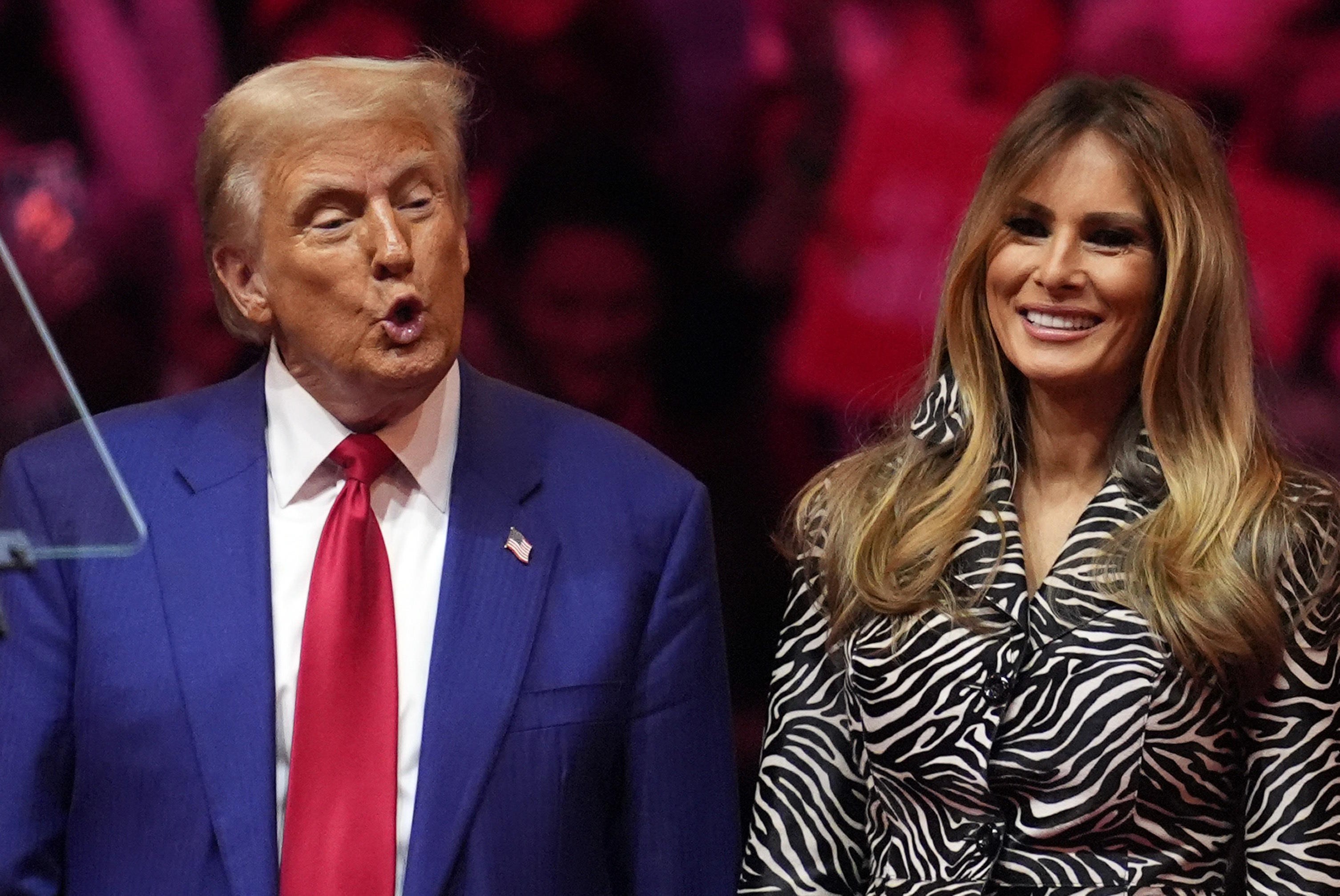 Donald Trump and former first lady stand on stage a campaign rally.