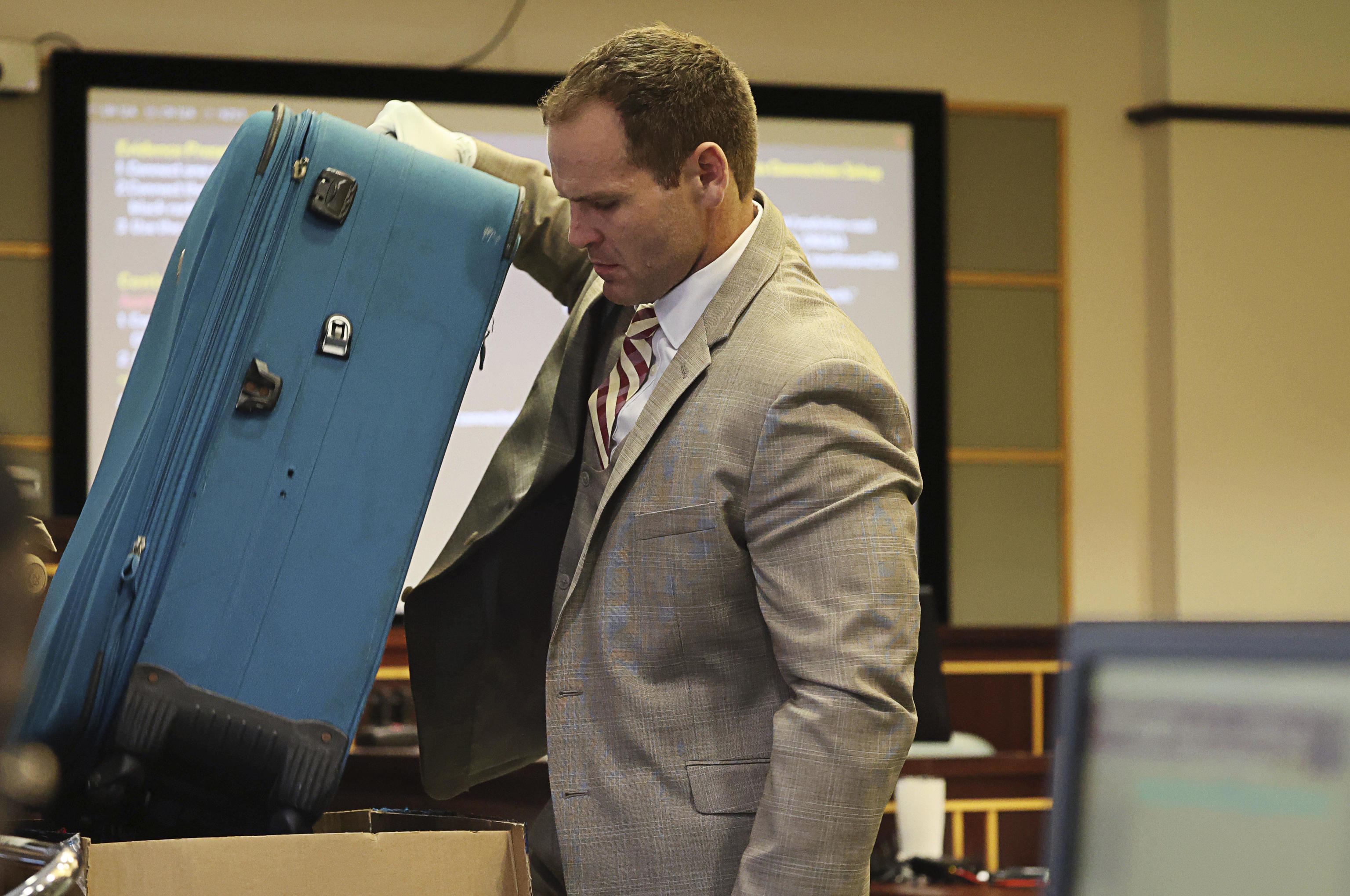 Prosecutor Dave Cacciatore Jr. pulls out the suitcase as evidence.