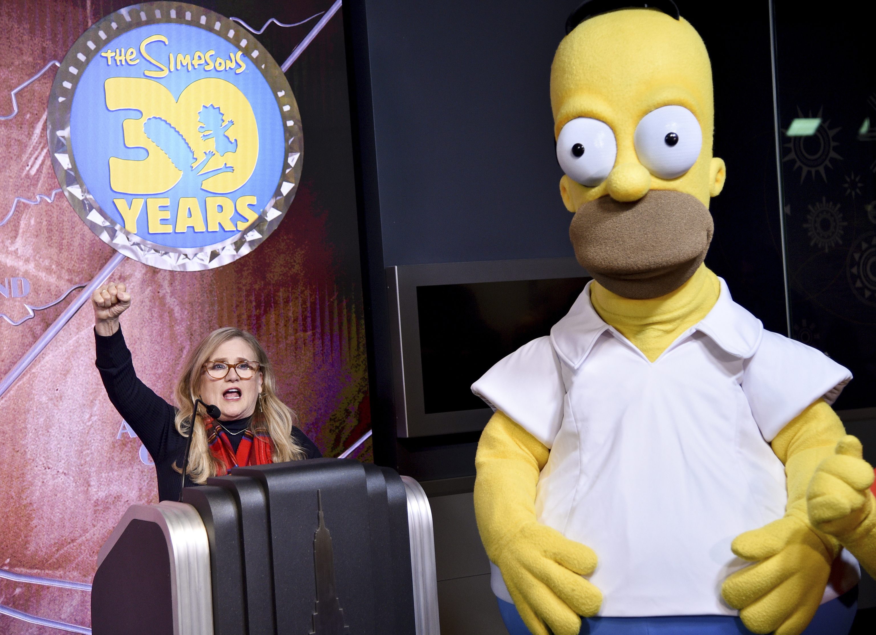 Nancy Cartwright, who voices the character Bart Simpson, left, appears with costumed character Homer Simpson during Fox's "The Simpsons" 30th anniversary celebration