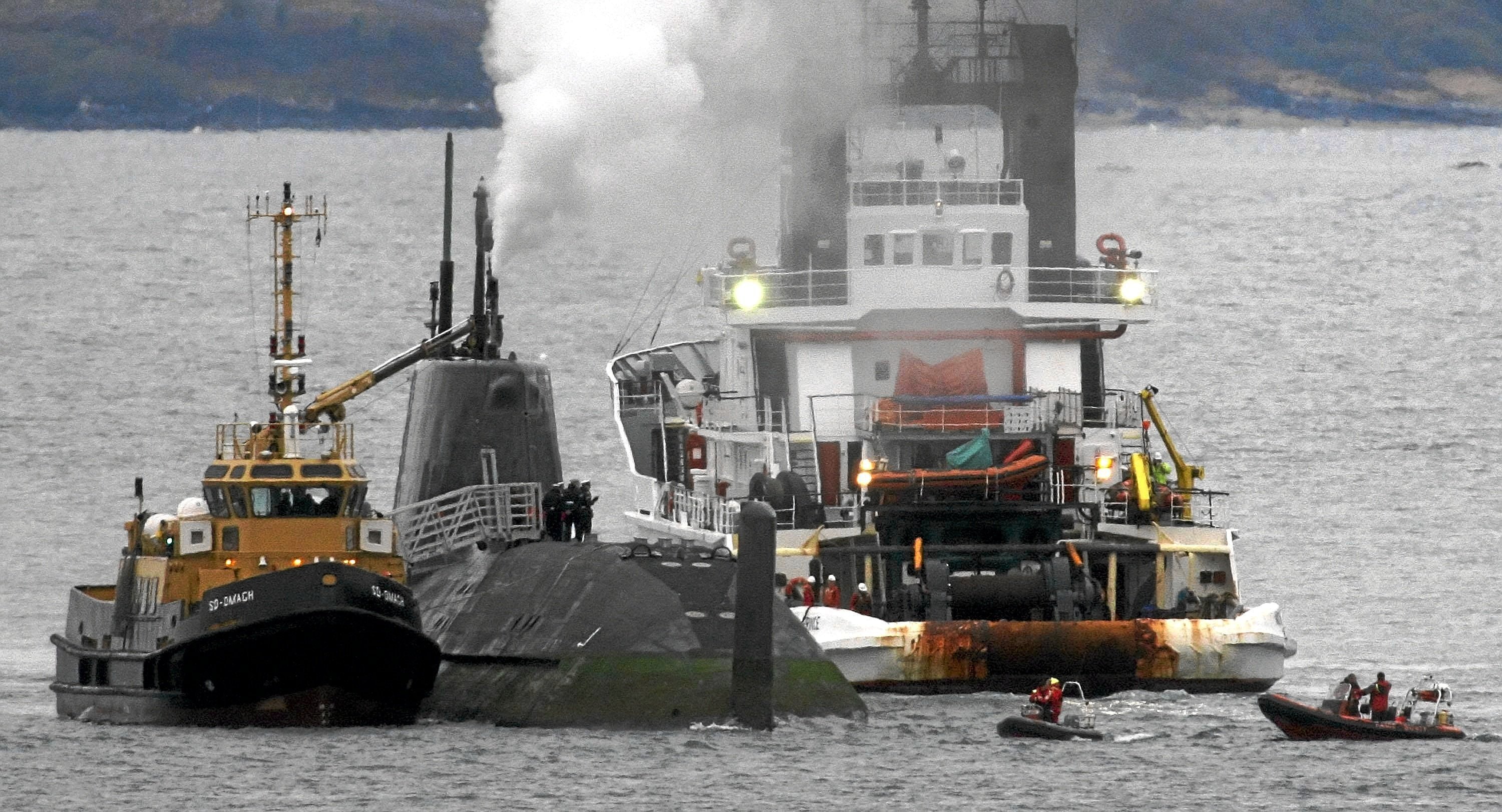 Tugs move in to assist the Royal Navy nuclear submarine HMS Astute, after it ran aground in shallow water off the Isle of Skye, Scotland,