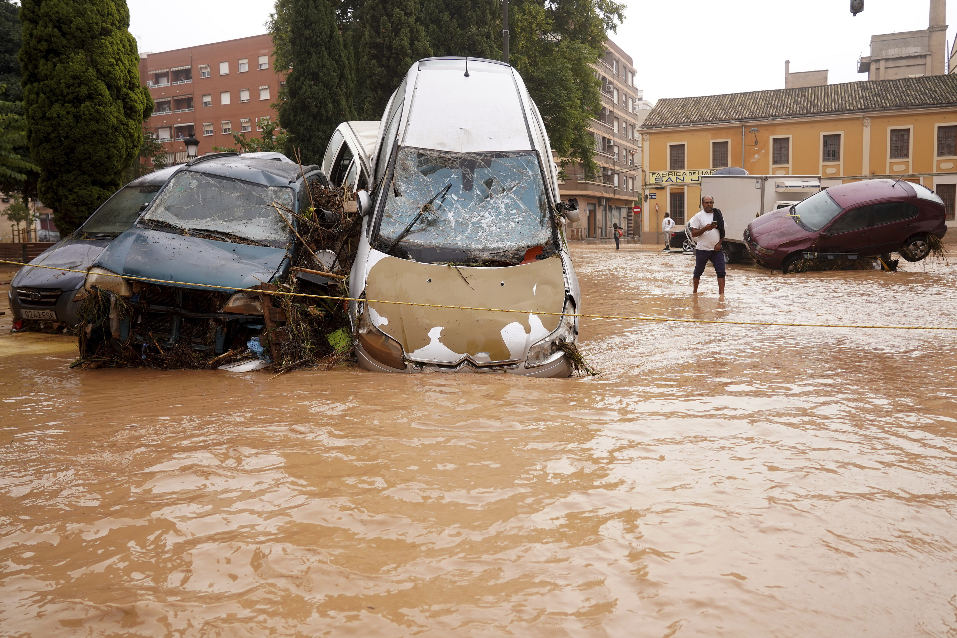 A man walks through flooded streets in Valencia