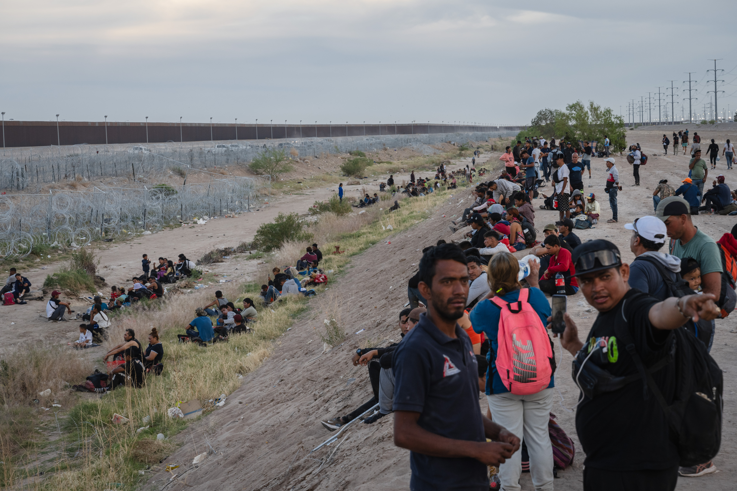 Migrants rest and prepare for the night on the bank of the dry riverbed of the Rio Grande at the US-Mexico border