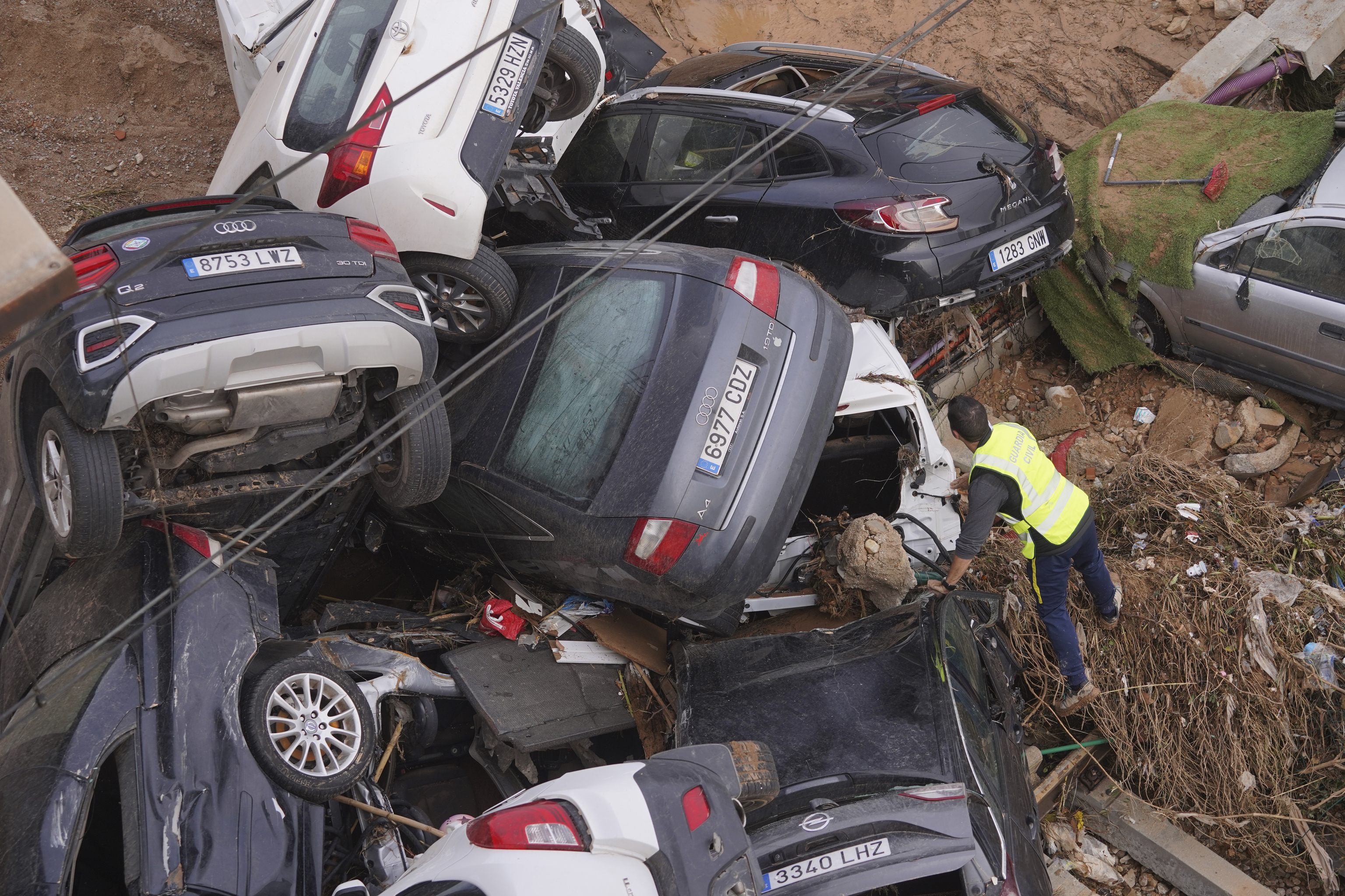 A civil guard seaches for survivors in cars piled up on the outskirts of Valencia, Spain.