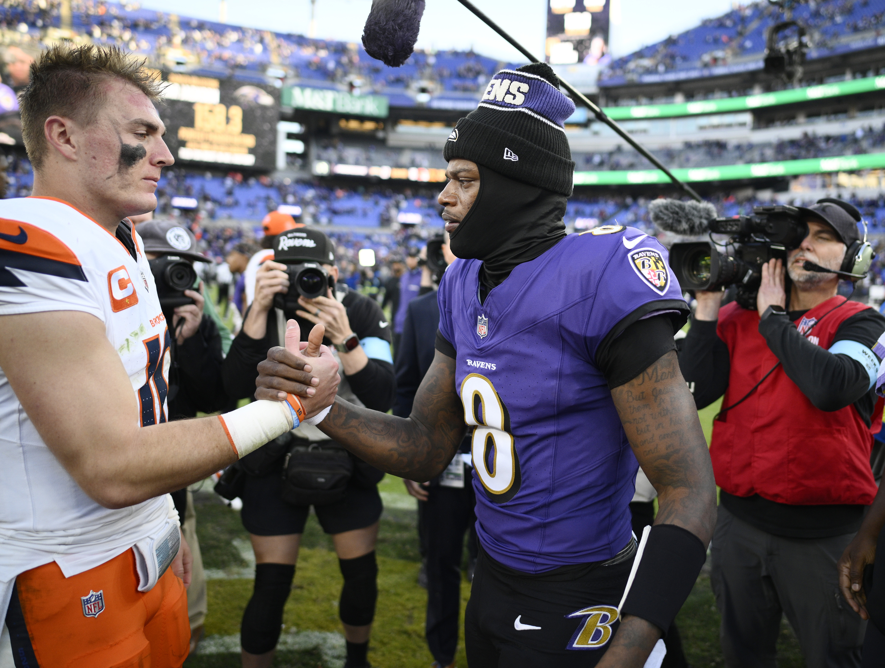 Denver Broncos quarterback Bo Nix, left, greets Baltimore Ravens quarterback Lamar Jackson (8).