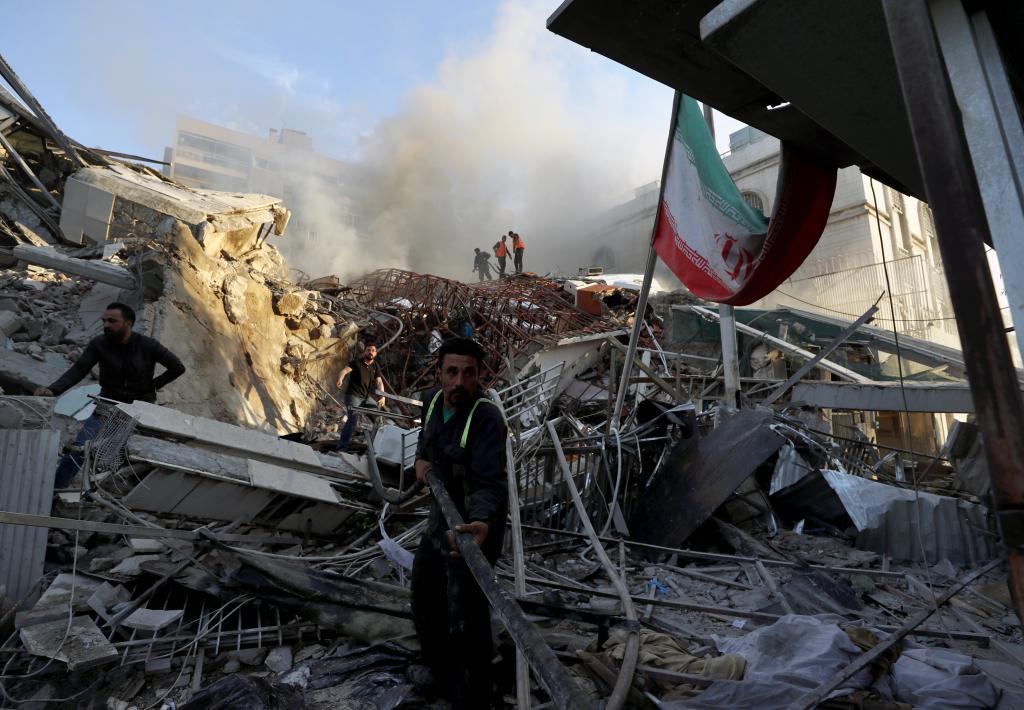 Emergency services work at a destroyed building hit by an air strike in Damascus, Syria