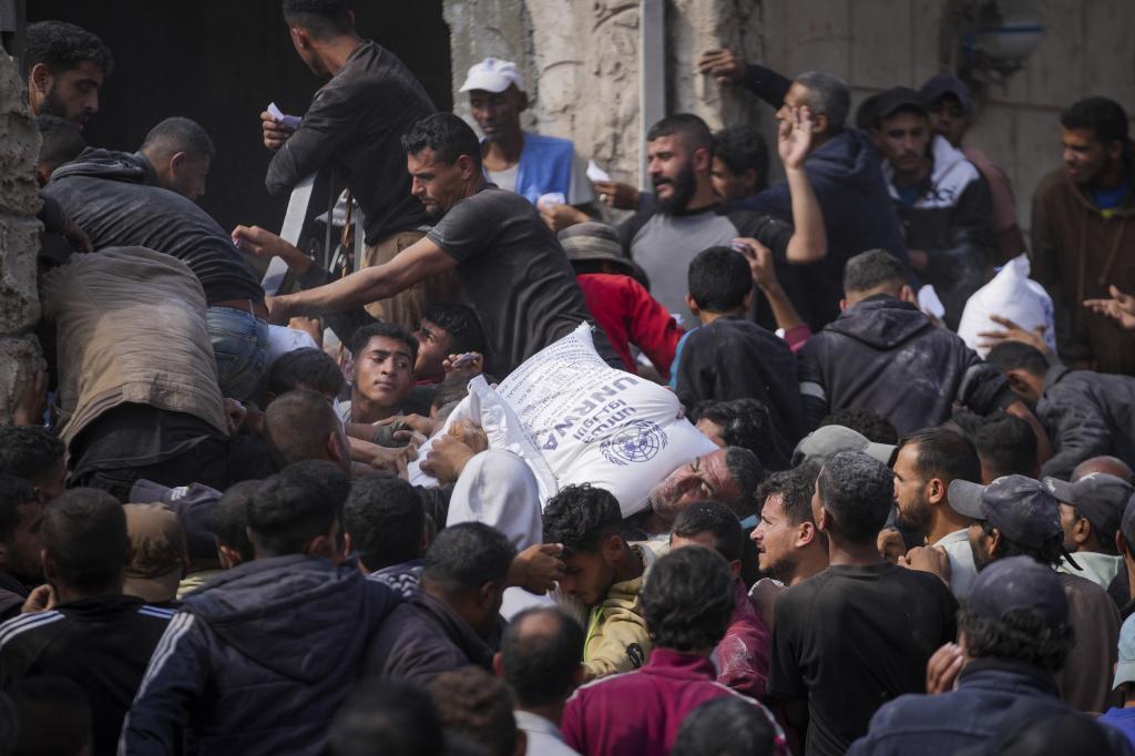 Palestinians gather to receive bags of flour distributed by UN agency UNRWA