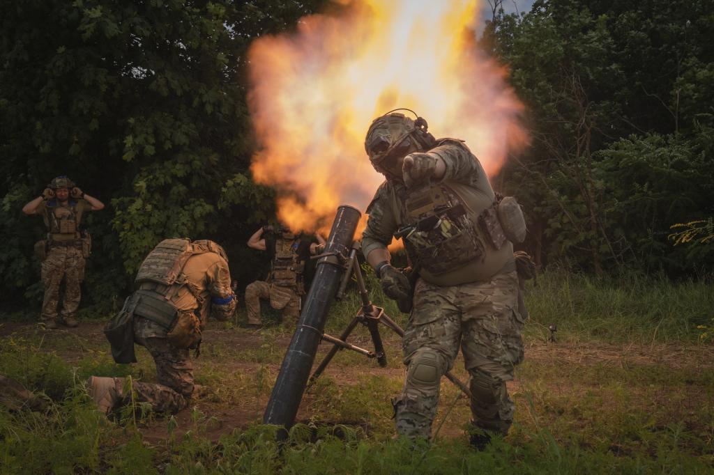 A Ukrainian soldier gestures as he fires toward Russian position on the frontline in Zaporizhzhia region