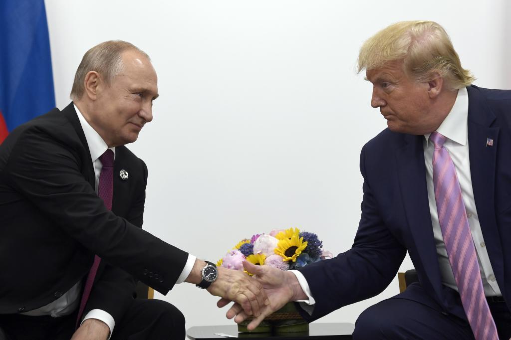 President Donald Trump, right, shakes hands with Russian President Vladimir Putin,