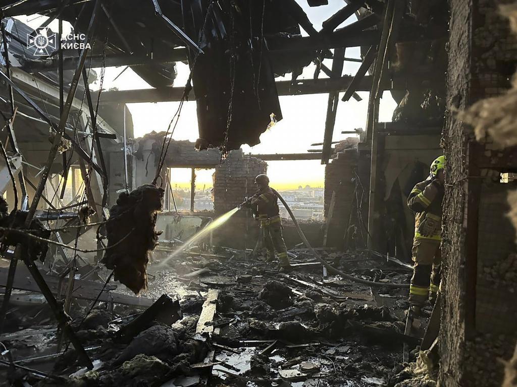 A rescuer puts out a fire resulted from Russian drone attack in Kyiv,