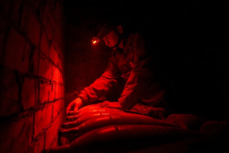 Bugskiy Gard unit gunner prepares mortar shells to be launched at Russian lines