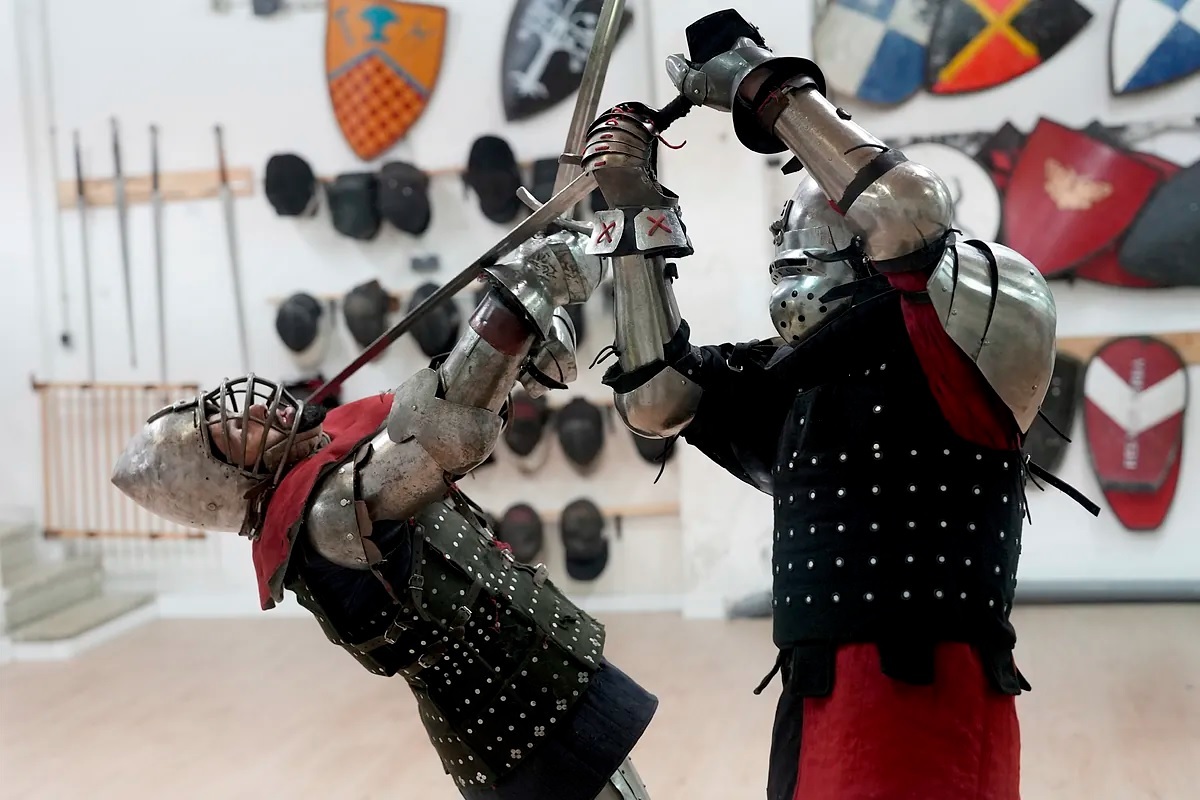 Two competitors in medieval armor fight during a training session