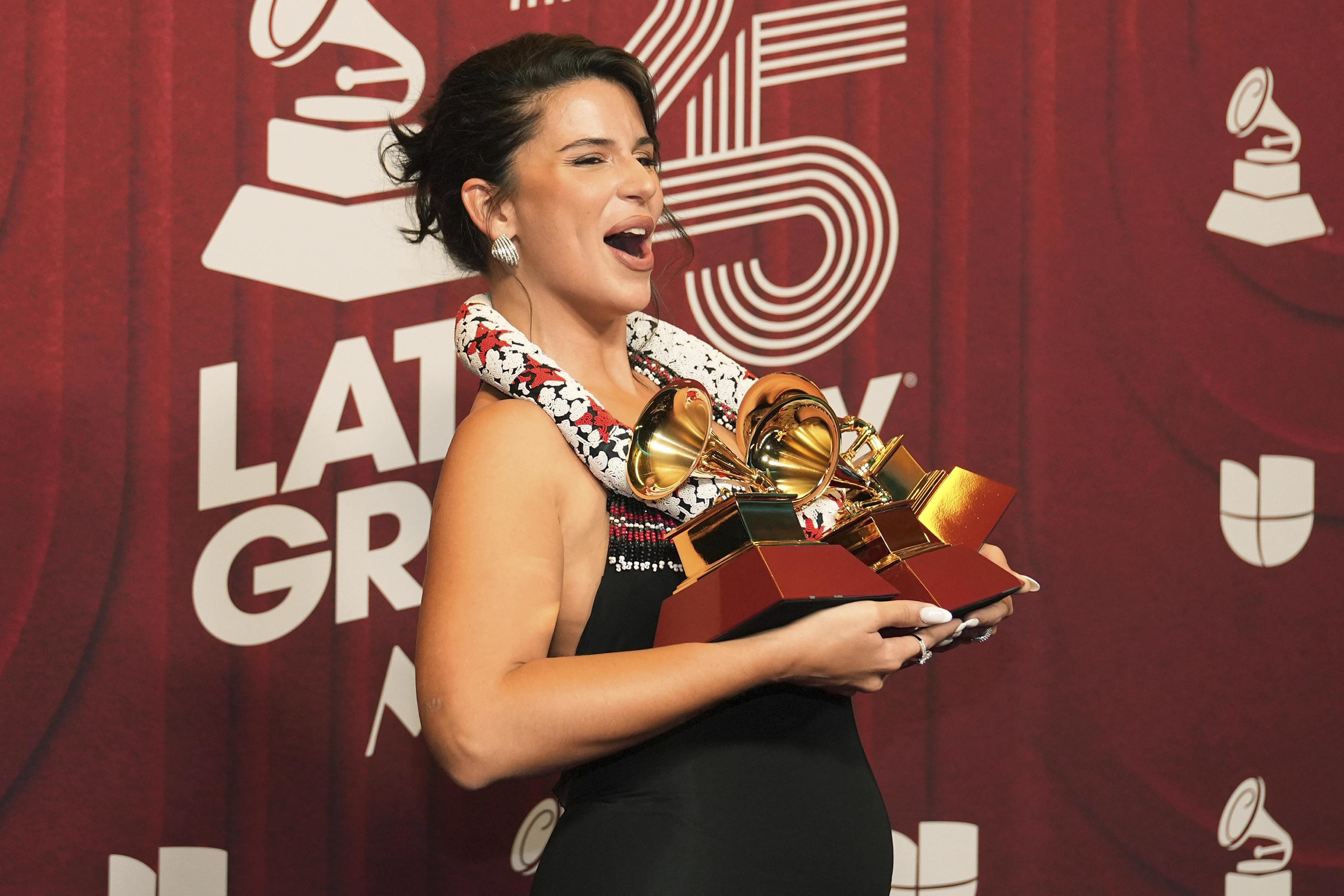 Nathy Peluso holding her three Latin Grammy Awards.