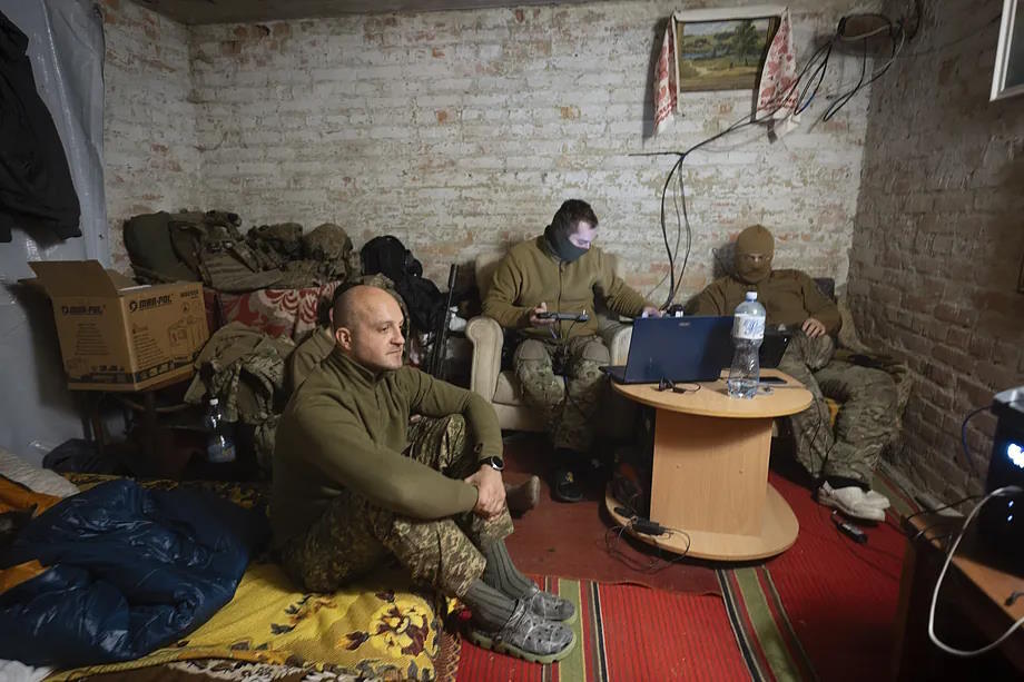 Soldiers from the Khartia brigade control the flight of a drone from their 'airbnb.'