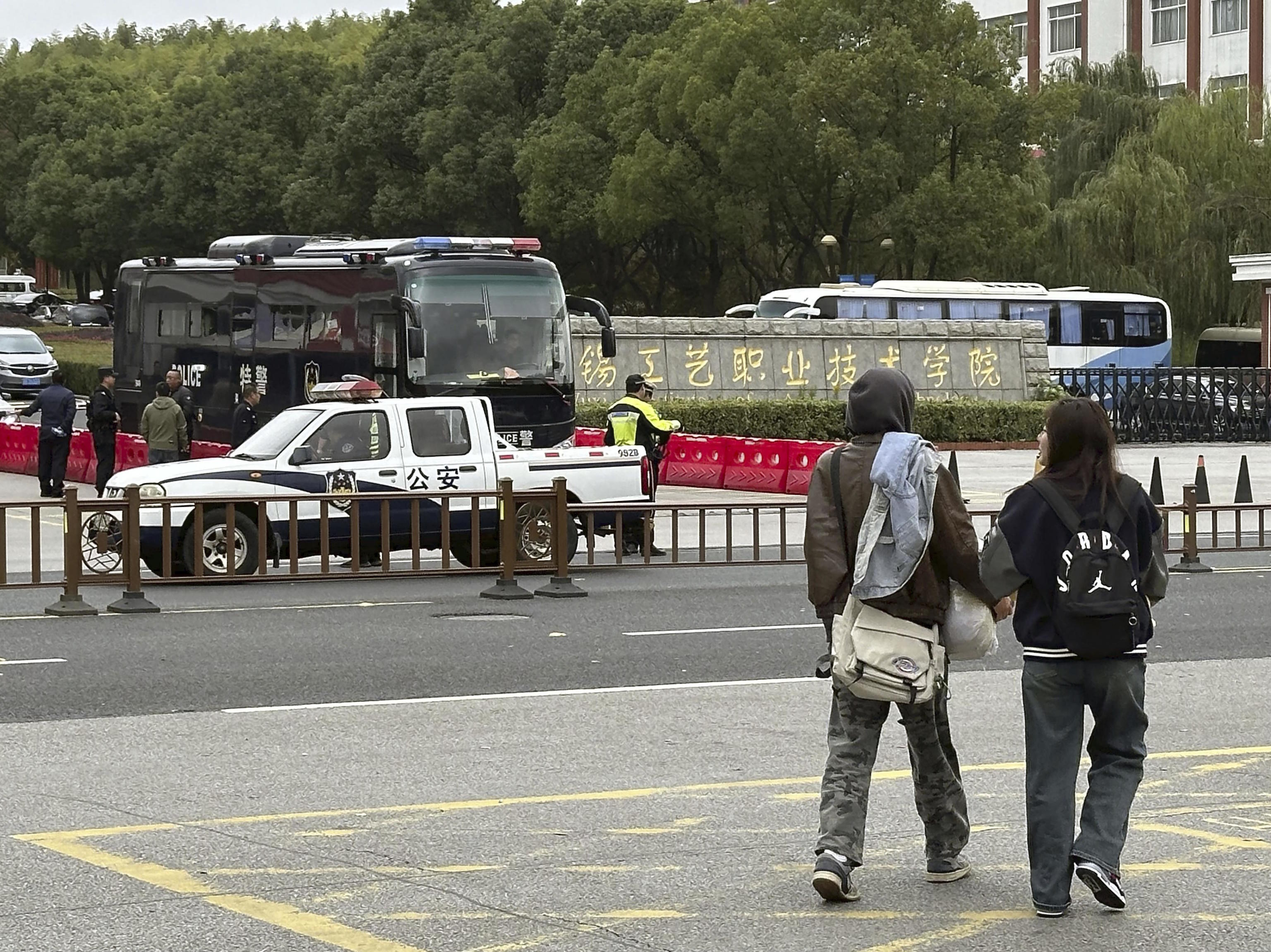 Police vehicles in front of the Wuxi Vocational Institute of Arts and Technology.