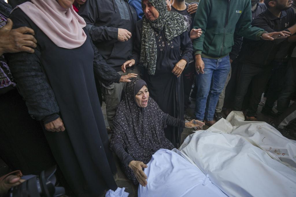 A woman mourns over the bodies of victims from an Israeli airstrike outside a hospital in Deir al-Balah