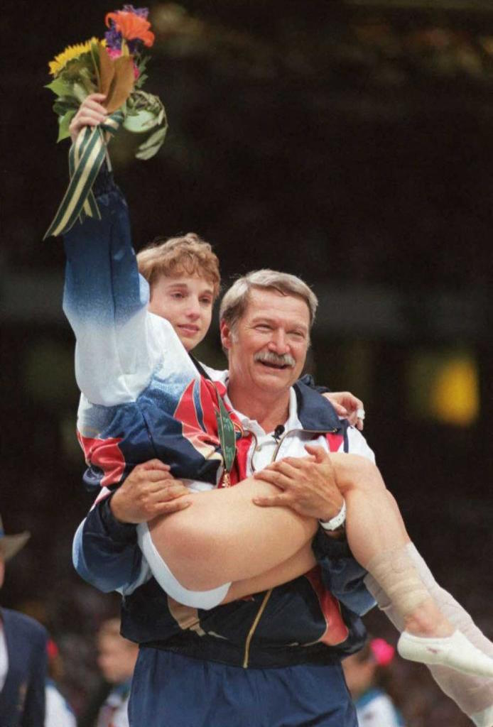 Bela Karolyi carries injured gymnast Kerri Strug.