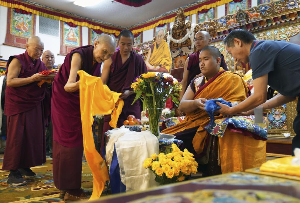 Monks bow and present "khata to teenage Buddhist lama, Jalue Dorje, at his 18th birthday and enthronement ceremony in Isanti