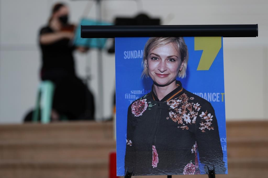 A musician plays a violin behind a photograph of cinematographer Halyna Hutchins during a vigil in her honor in Albuquerque