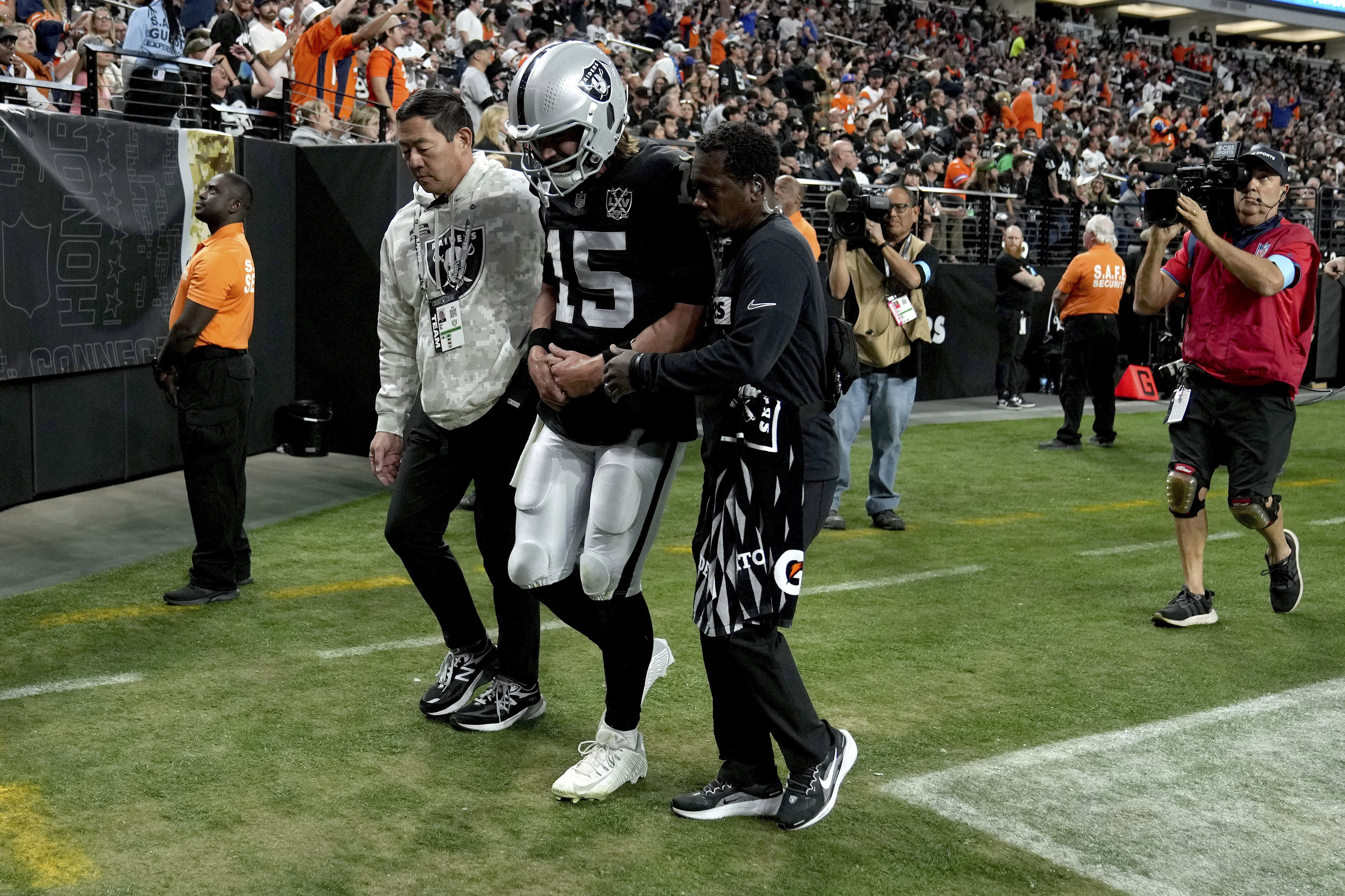 Las Vegas Raiders quarterback Gardner Minshew (15) is helped off the field after an injury against he Denver Broncos.