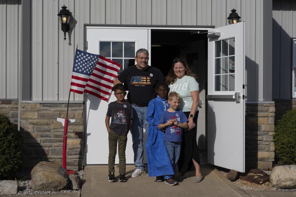 Mike and Erin Young and their three adopted kids from left, Lucas, 8, Gianna, 7, and Isaac, 5, pose for a family photo outside the Trenton Township polling place after Mike voted for Donald Trump on Election Day